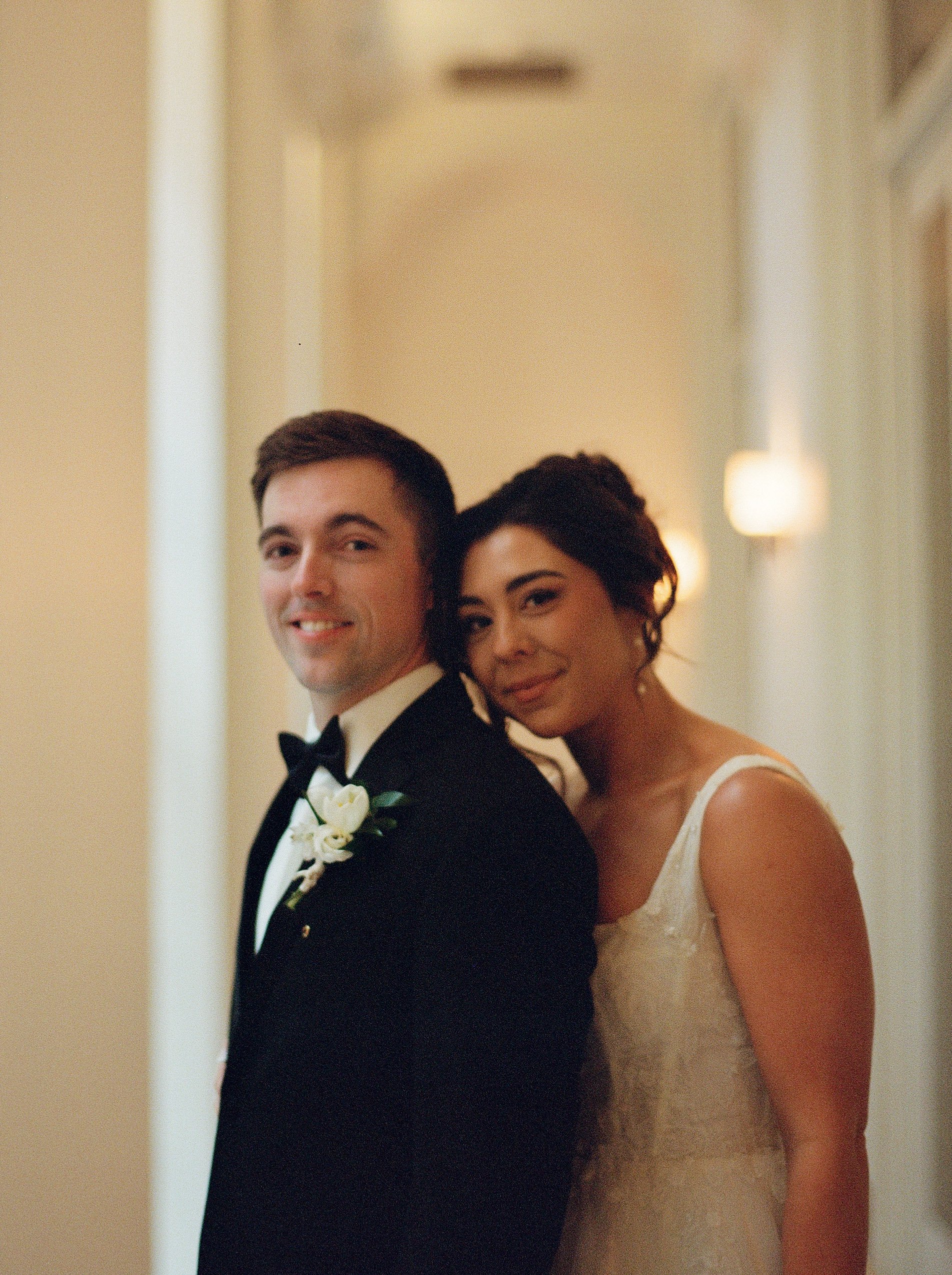 Bride and groom posing together in a softly lit hallway during their Shinola Hotel wedding day