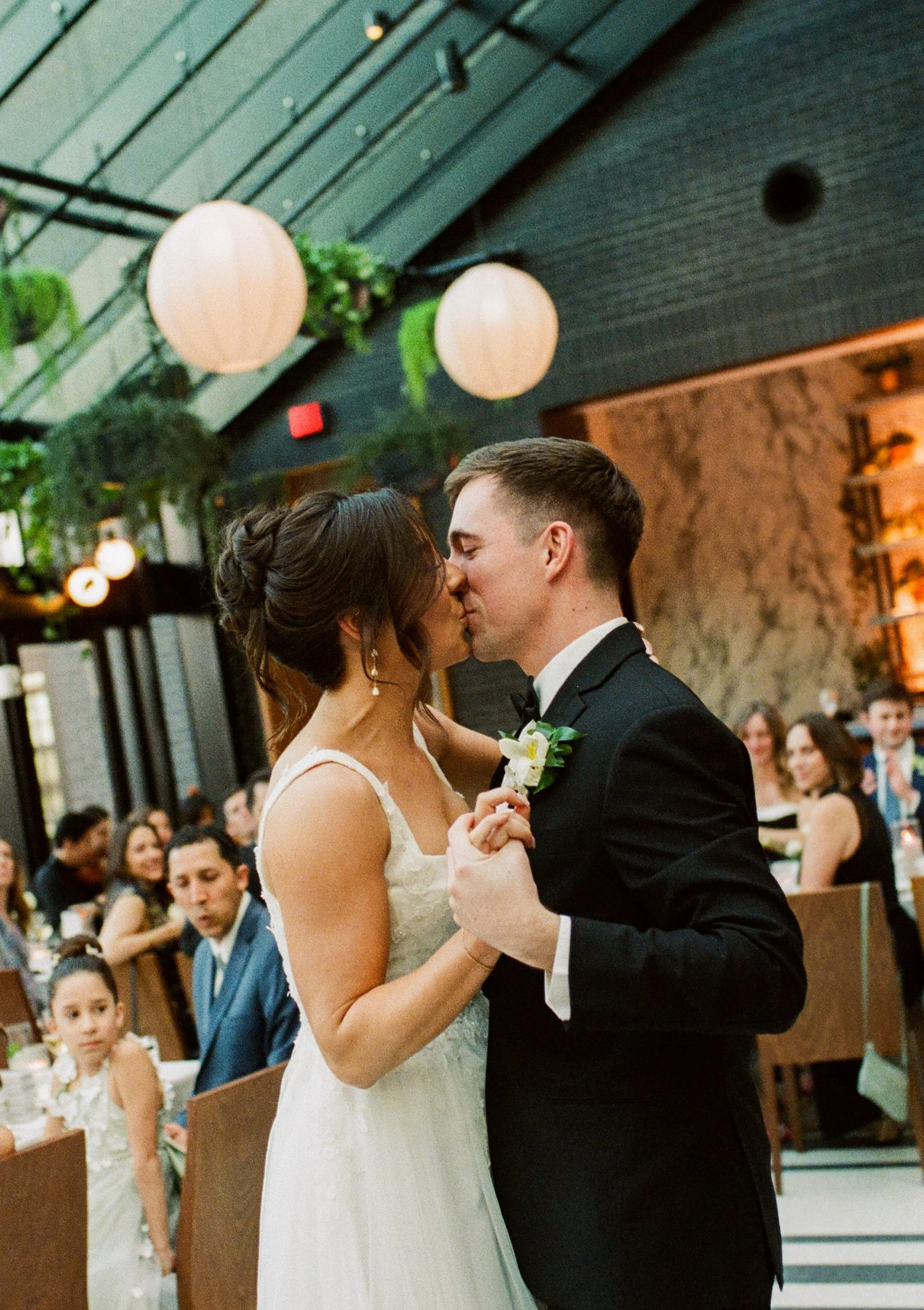 Bride and groom sharing their first dance surrounded by guests during their wedding reception