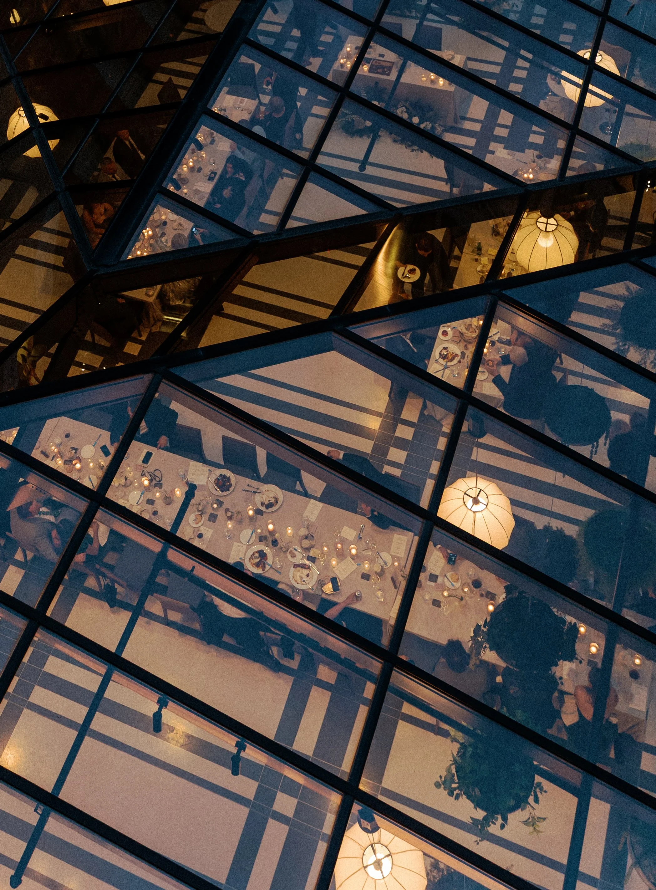 Overhead view of a candlelit wedding reception seen through the glass ceiling at Shinola Hotel