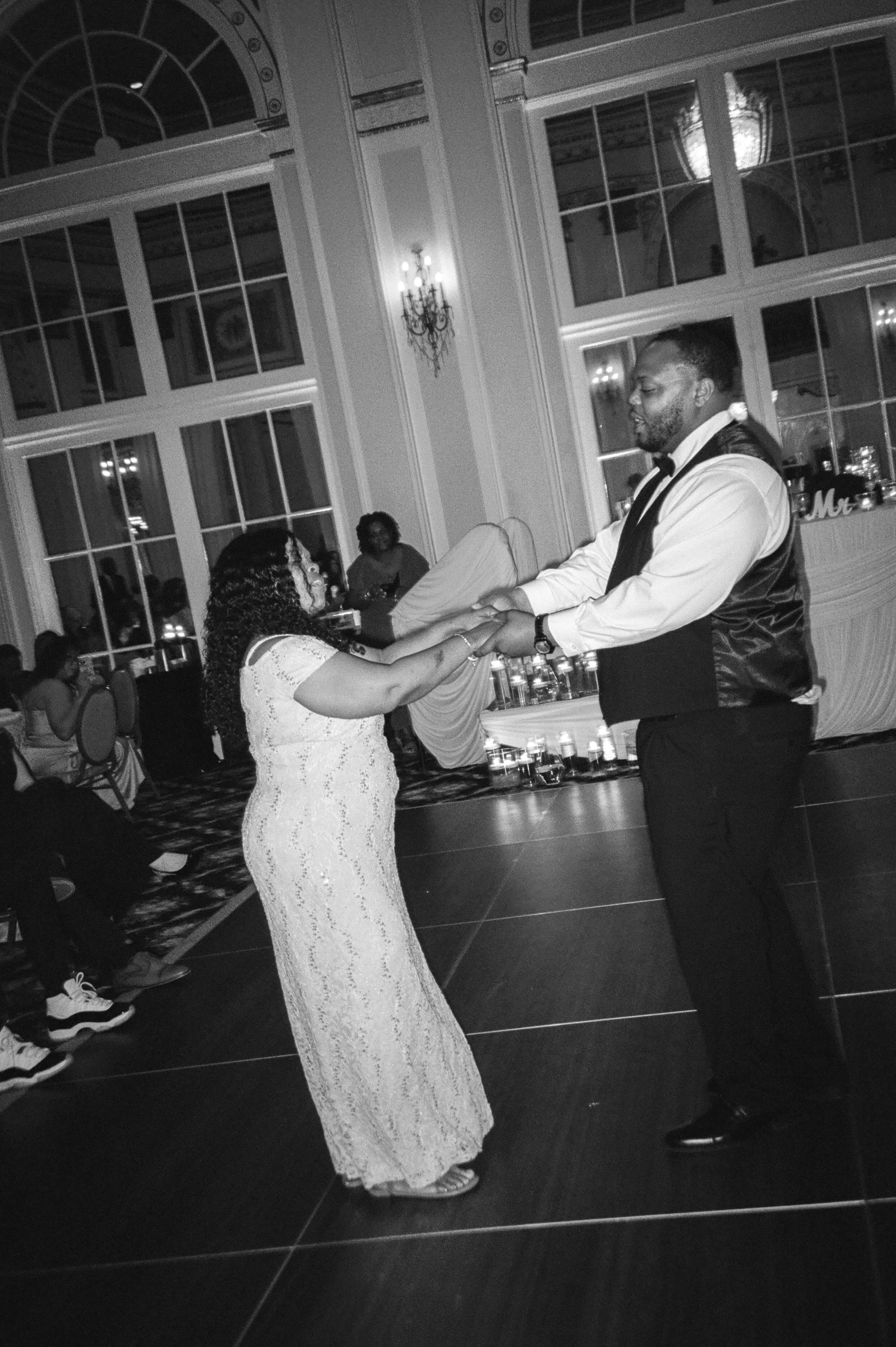 Black and white reception photo of a couple dancing together on the wedding dance floor