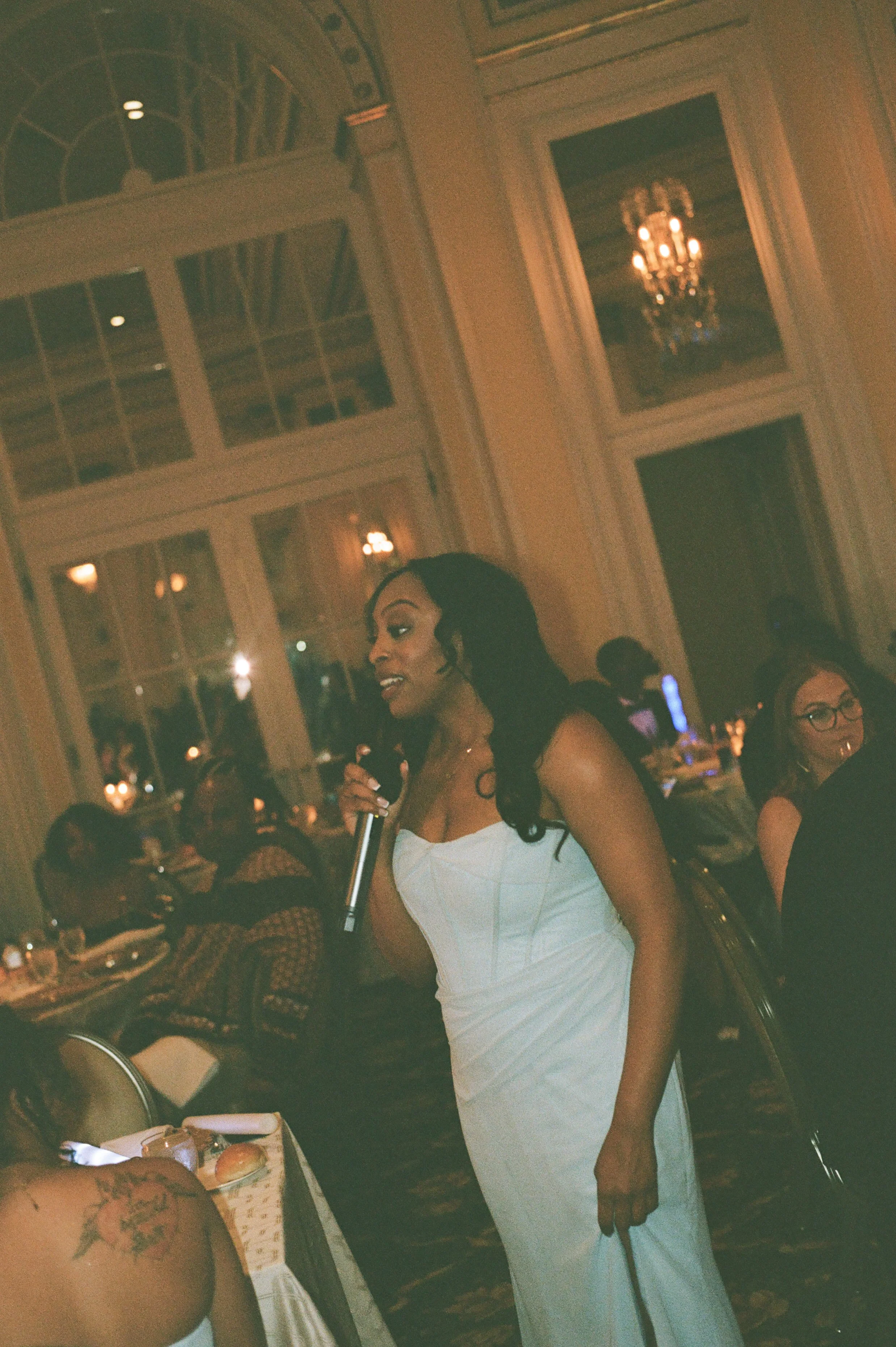 Bridesmaid giving a heartfelt wedding speech during the candlelit reception