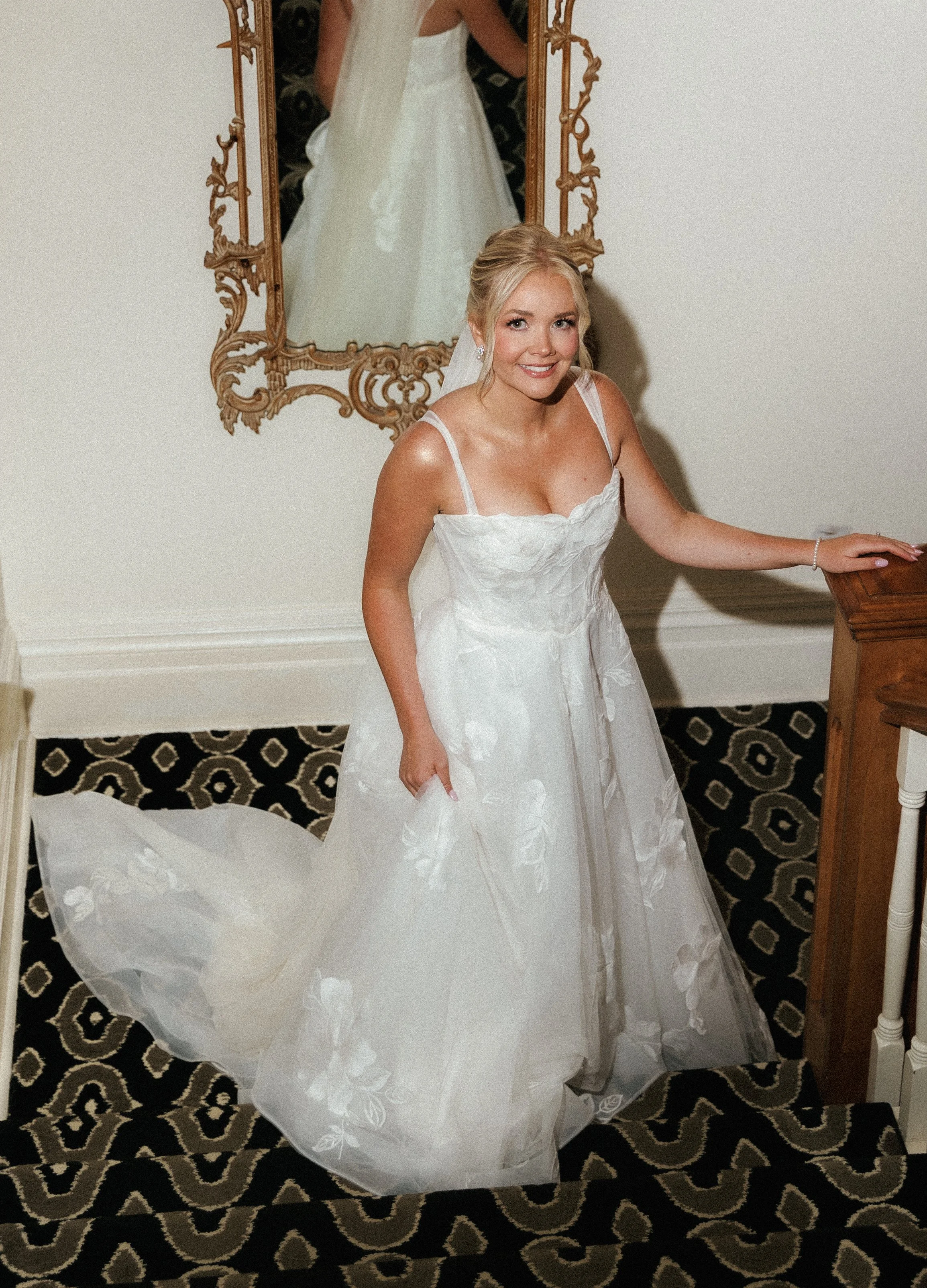 Bridal portrait in a hotel hallway featuring a floral wedding gown and long veil at Stafford's Perry Hotel.