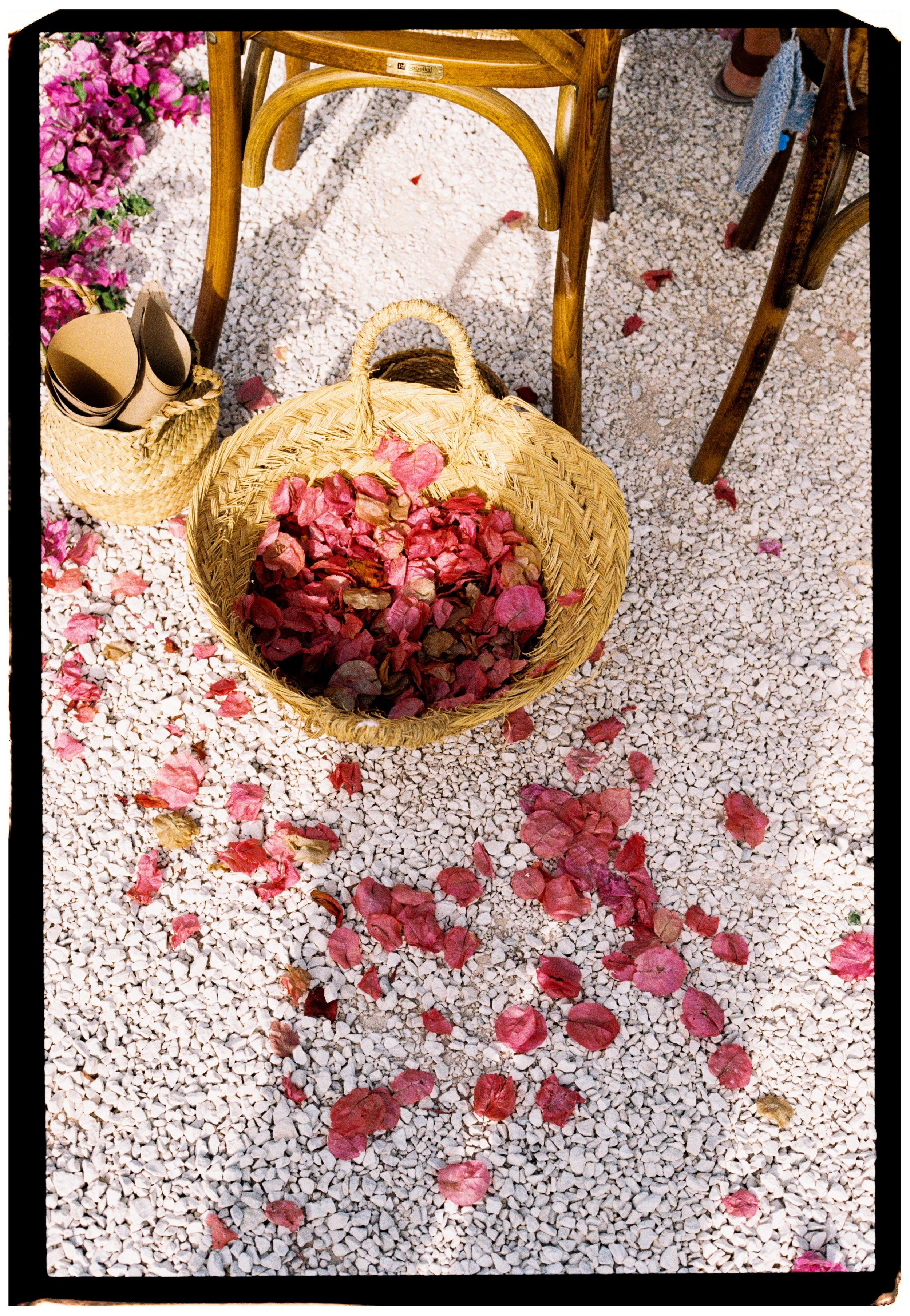 Woven basket filled with pink flower petals ready for the ceremony exit.