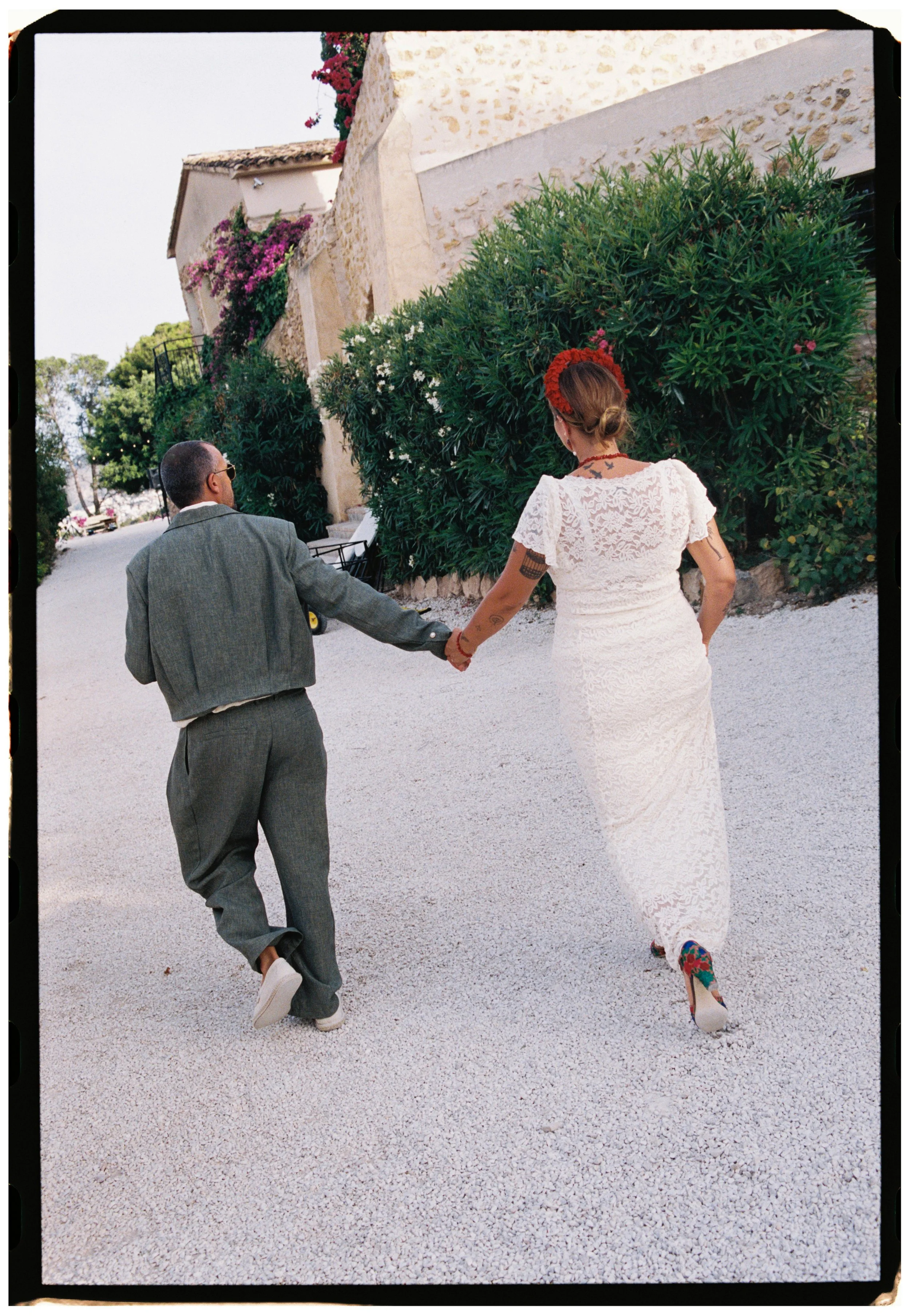 Bride and groom walking hand in hand through a quiet courtyard after their Spain wedding ceremony.