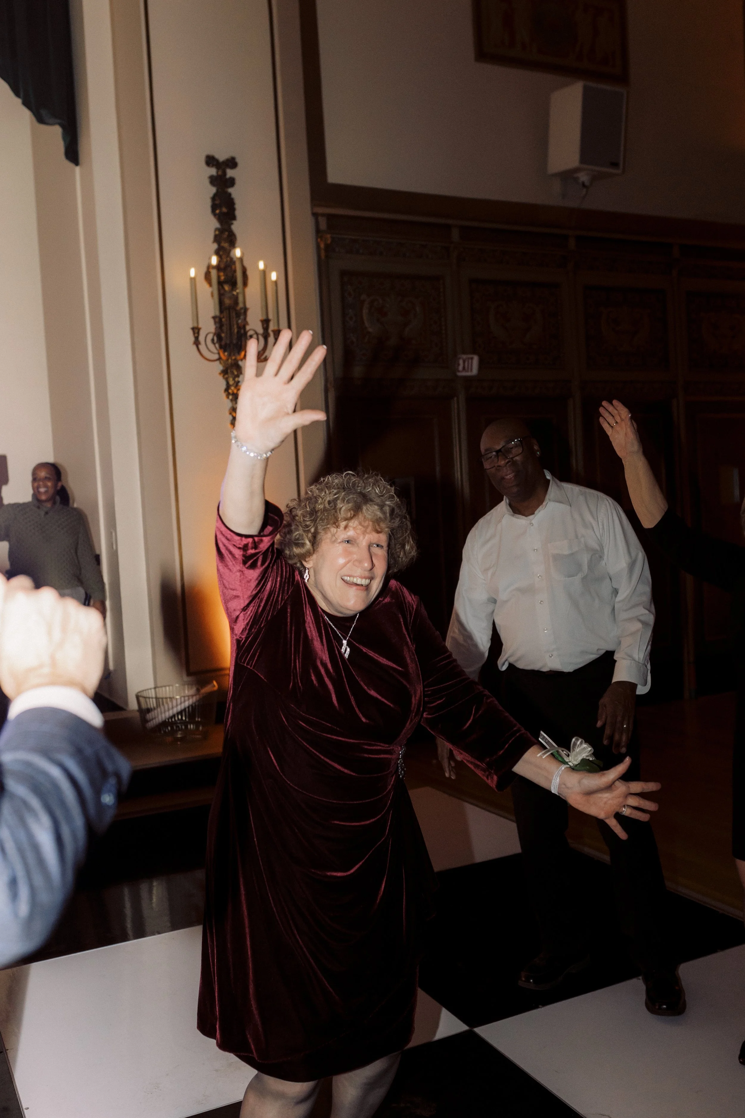 A wedding guest in a red dress dancing at a downtown Detroit wedding