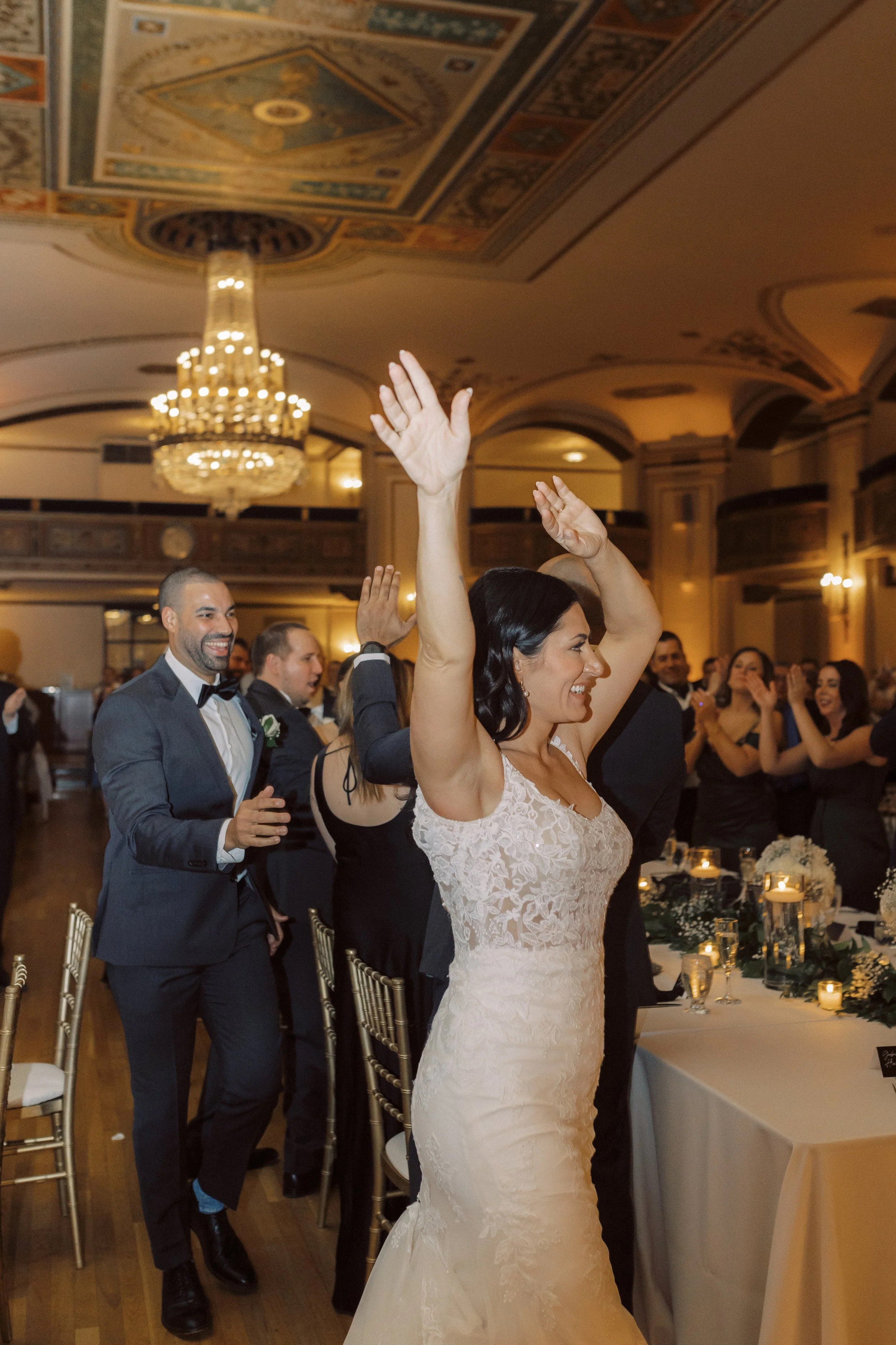 A bride and groom enter their ceremony at their downtown Detroit wedding with smiles on their faces