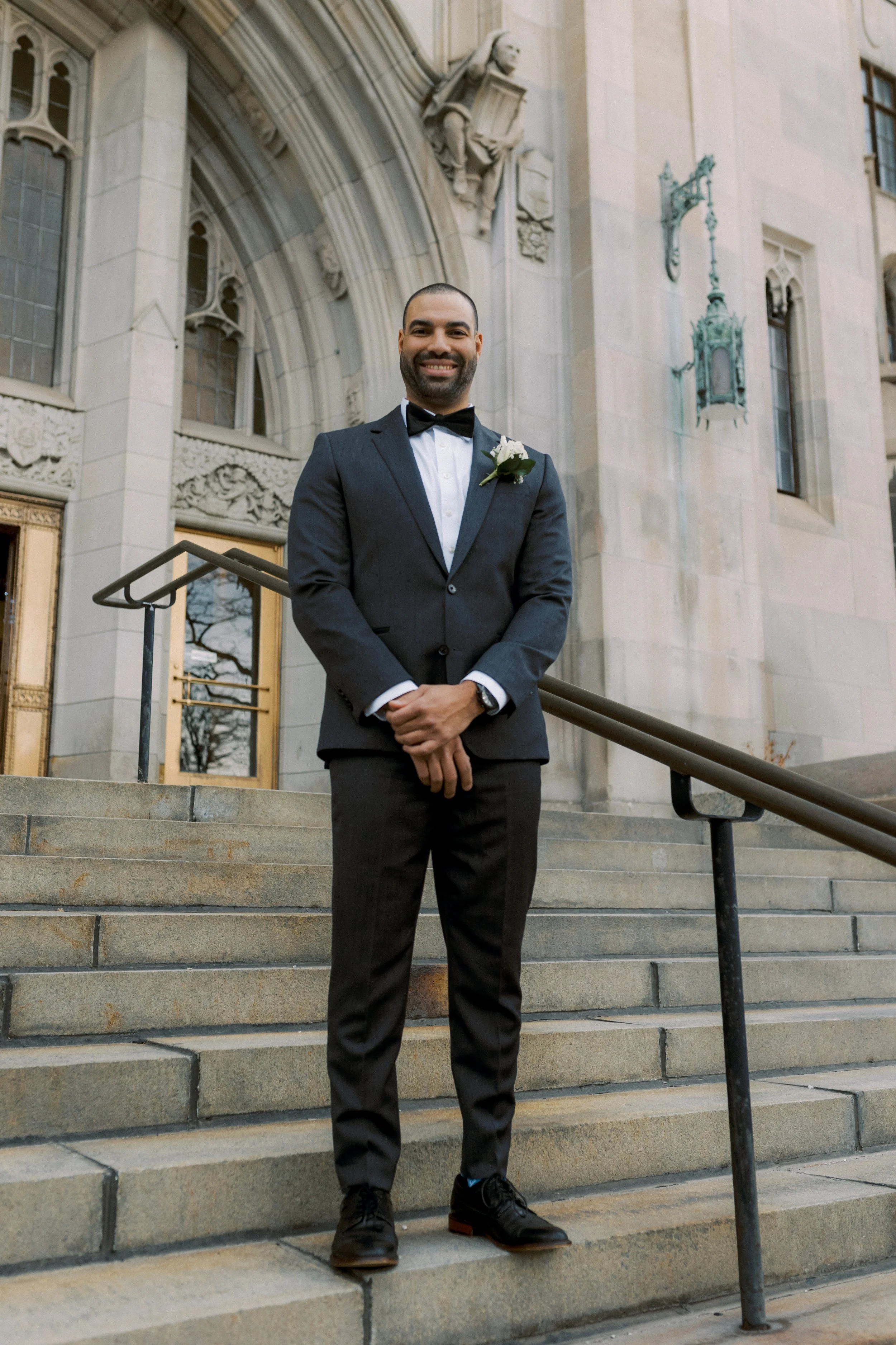 A portrait of a groom on the steps of The Masonic Temple in downtown Detroit