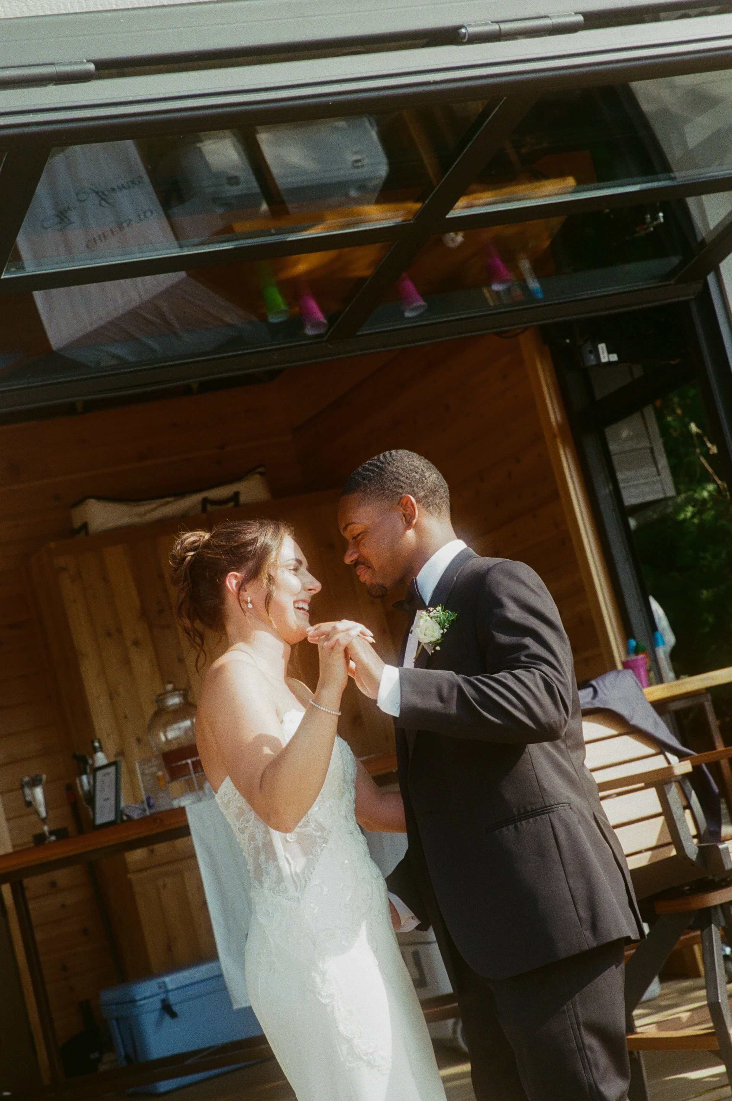 Newlyweds dancing together outside during their relaxed Northern Michigan backyard wedding reception.