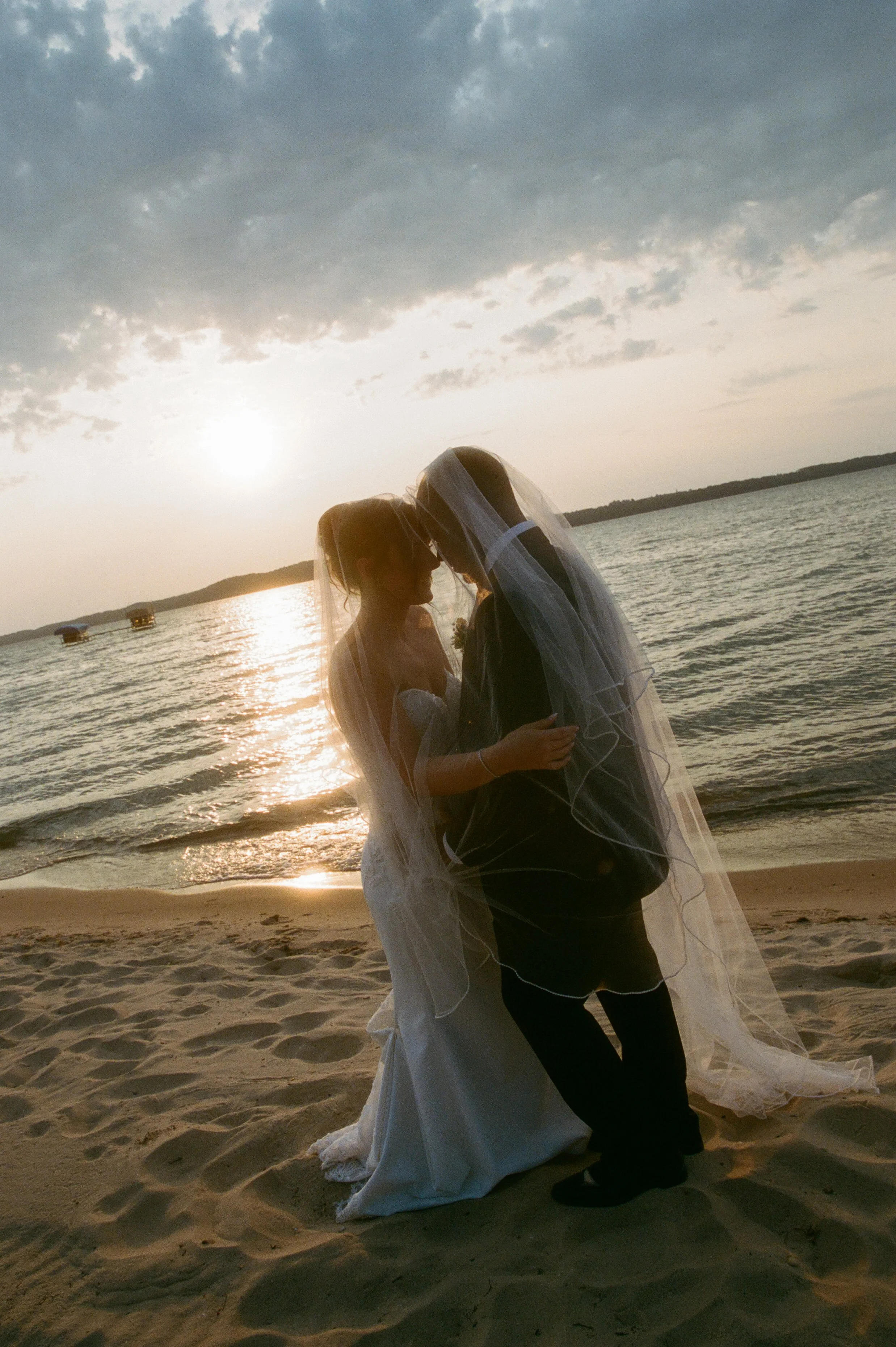 Bride and groom sharing a quiet moment beneath her veil during their Northern Michigan backyard wedding.