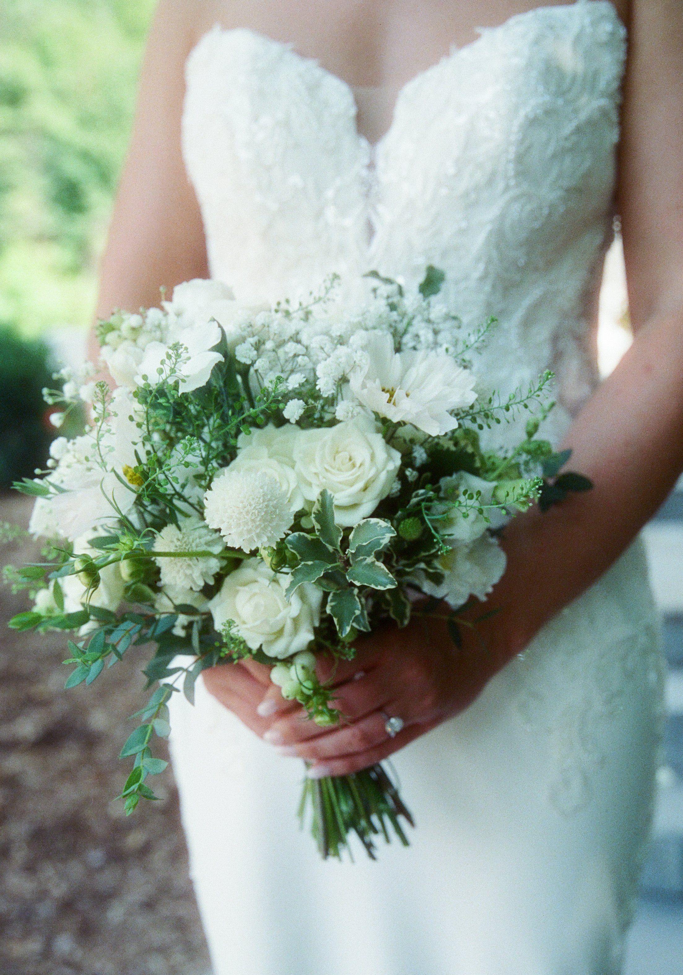 Close-up of the bride’s white and green floral wedding bouquet.