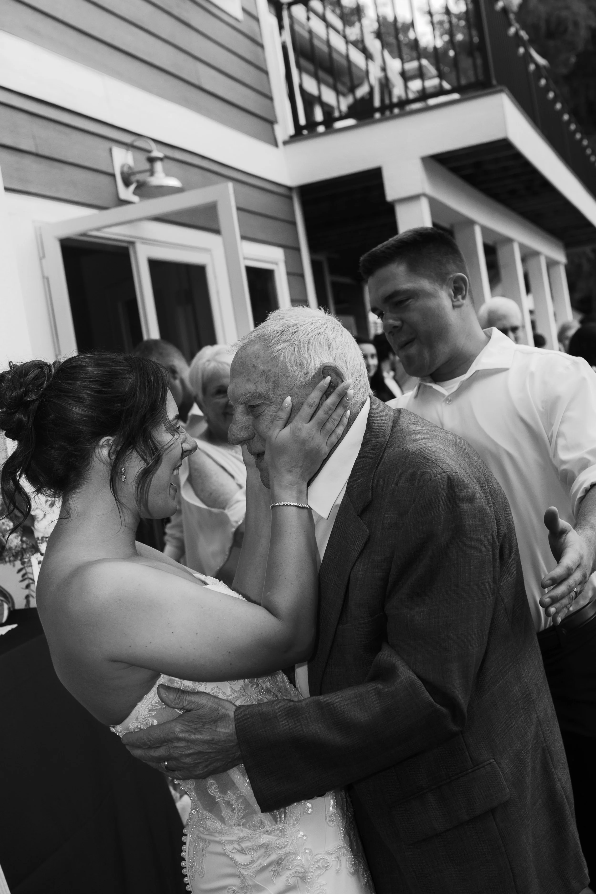 Black and white photo of the bride sharing an emotional moment with an older family member.