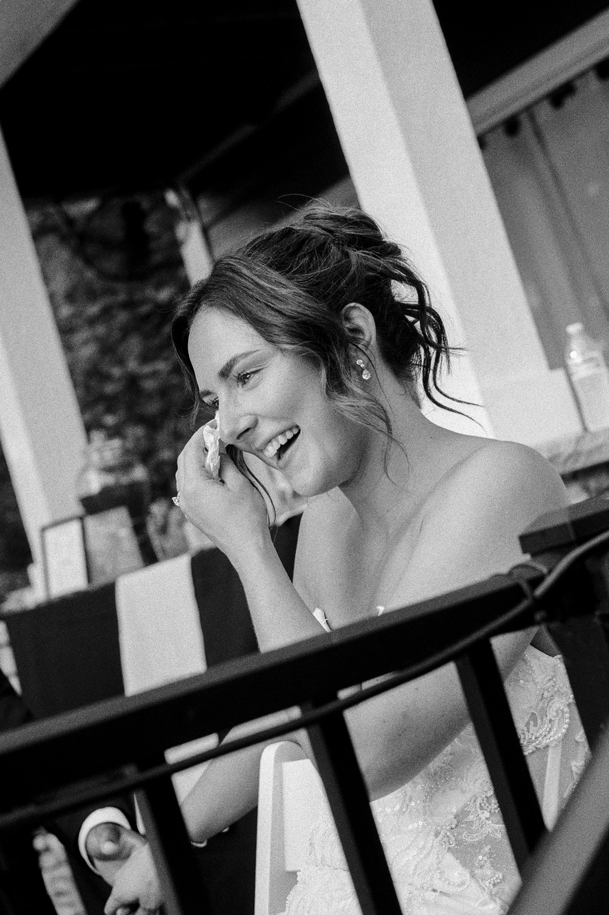 Black and white candid photo of the bride wiping away tears during her Northern Michigan backyard wedding.