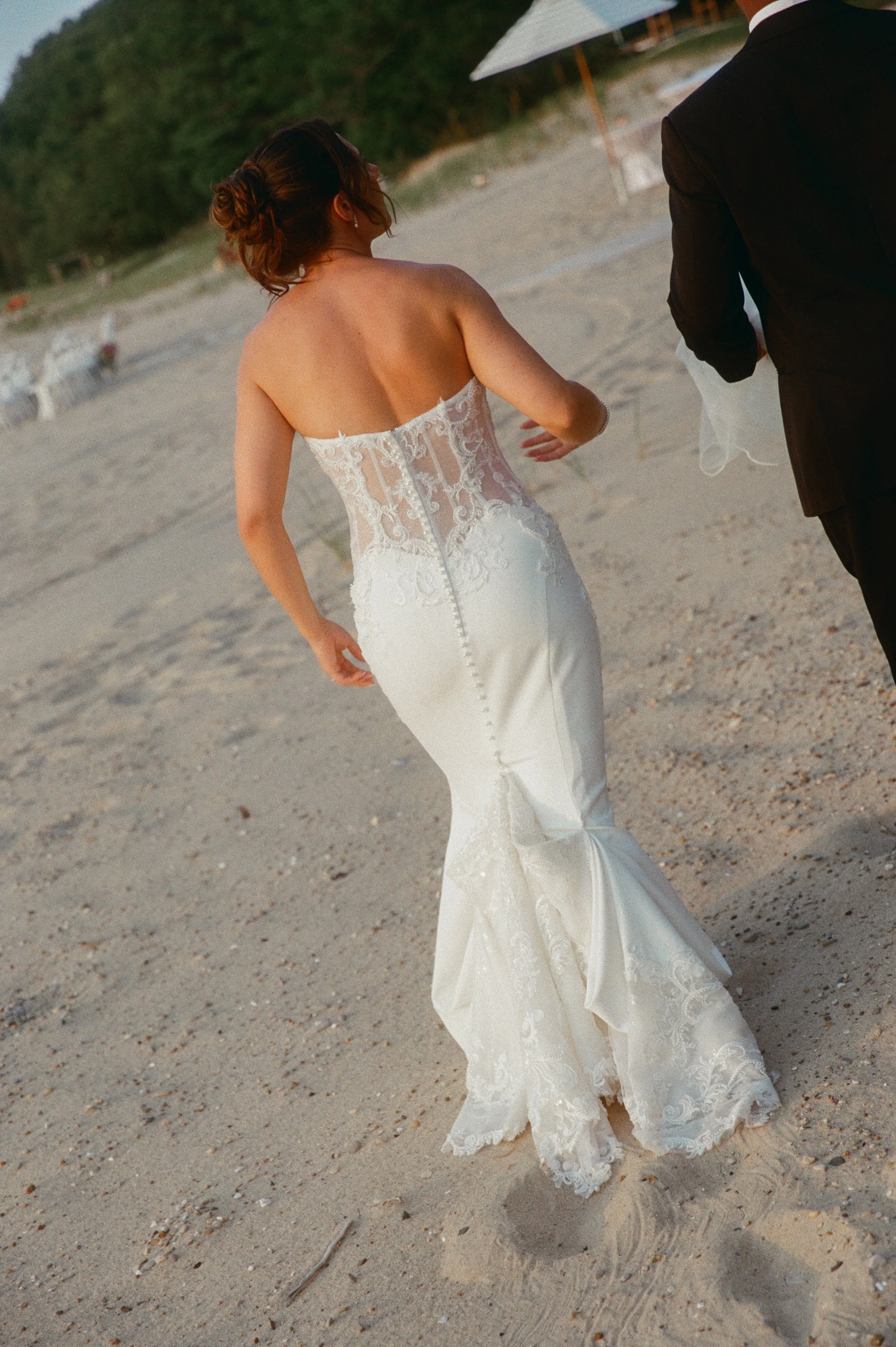 A picture of the back of the brides wedding dress as she's walking away.