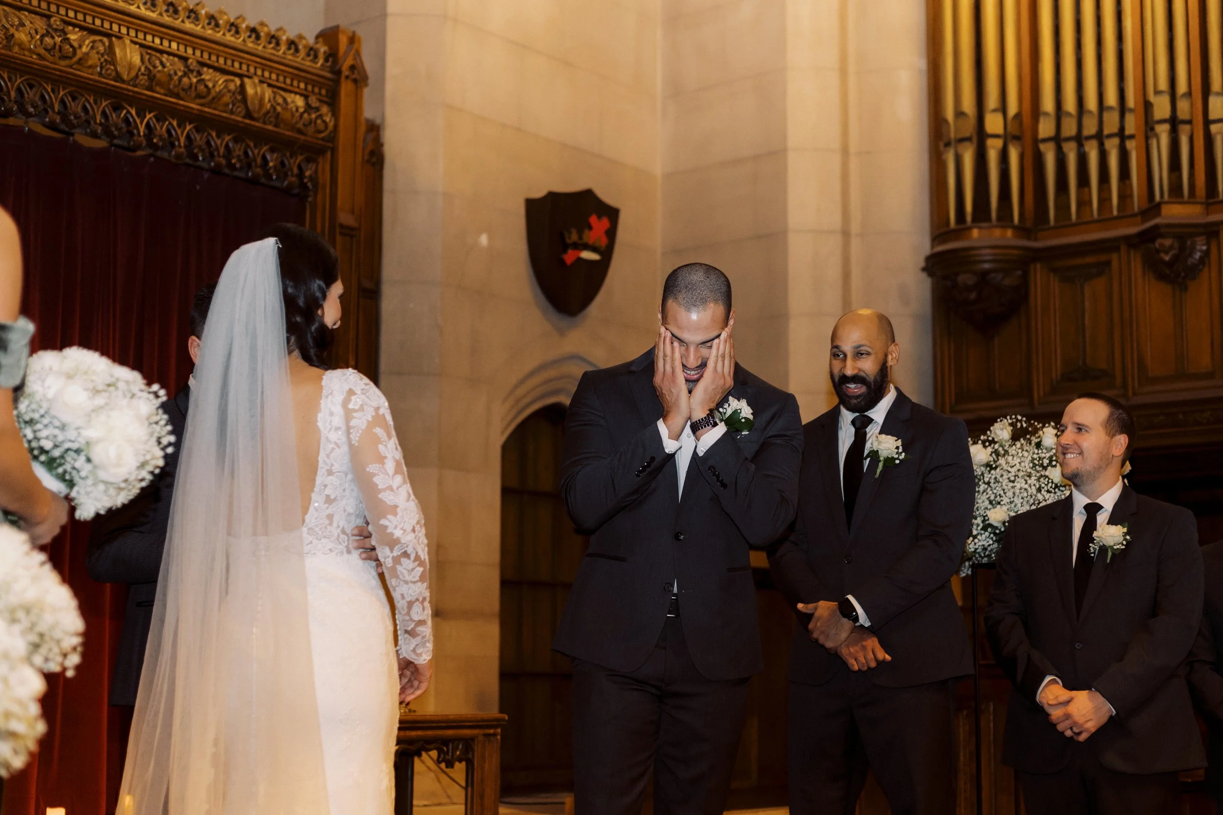 Groom reacting emotionally as he sees the bride at the altar during their downtown Detroit wedding ceremony.