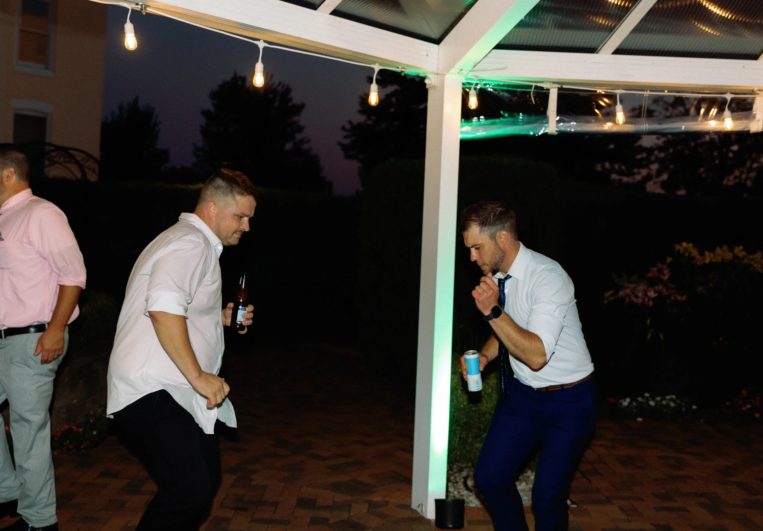 Wedding guests dancing together during the evening reception celebration.