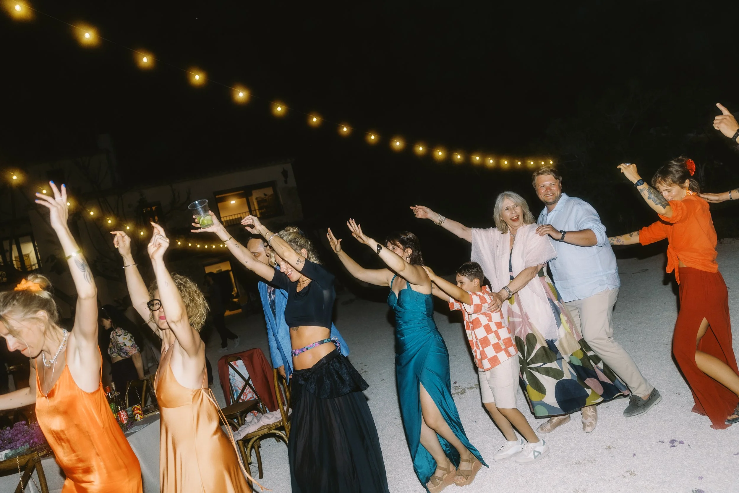 Guests dancing beneath string lights at an outdoor Spain wedding reception.