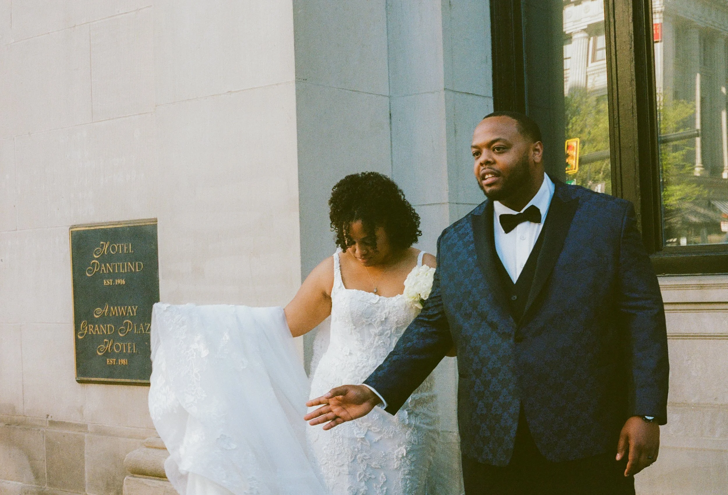 Bride and groom walking outside the Amway Grand Plaza Hotel in downtown Grand Rapids on their wedding day