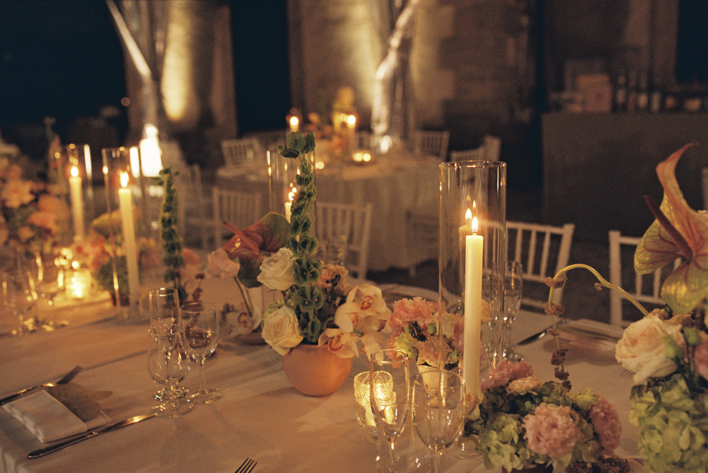 Elegant candlelit reception tablescape with orchids, hydrangeas, and glowing candles at a Vizcaya Museum and Gardens wedding reception.