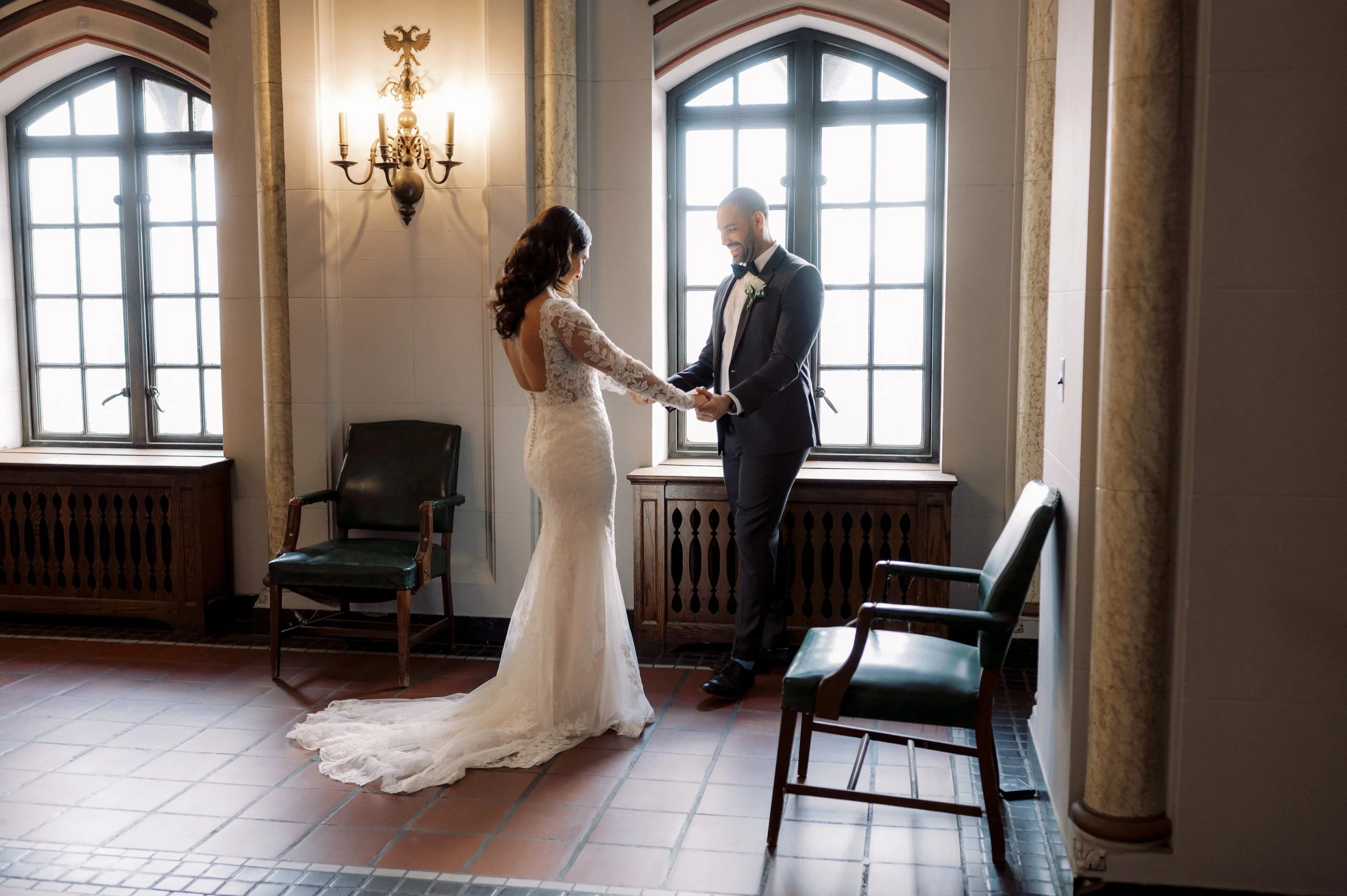 Bride and groom laughing together during their first look at their downtown Detroit wedding.