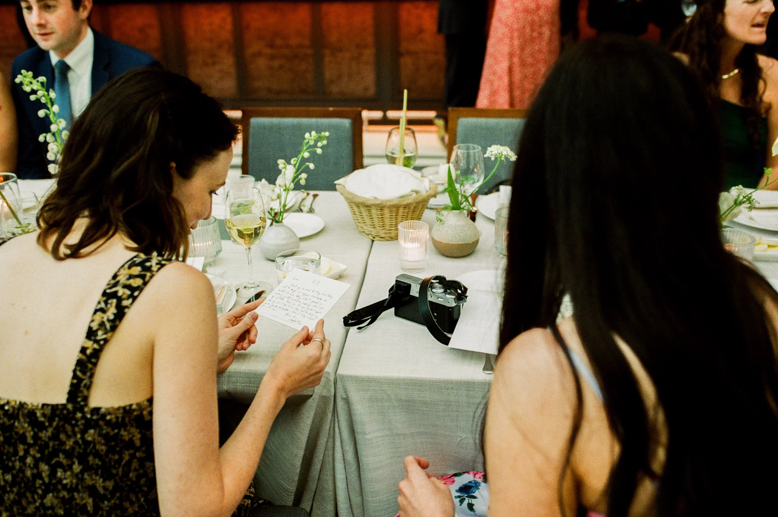 Wedding guest reading a handwritten note at the reception table during a Shinola Hotel wedding celebration
