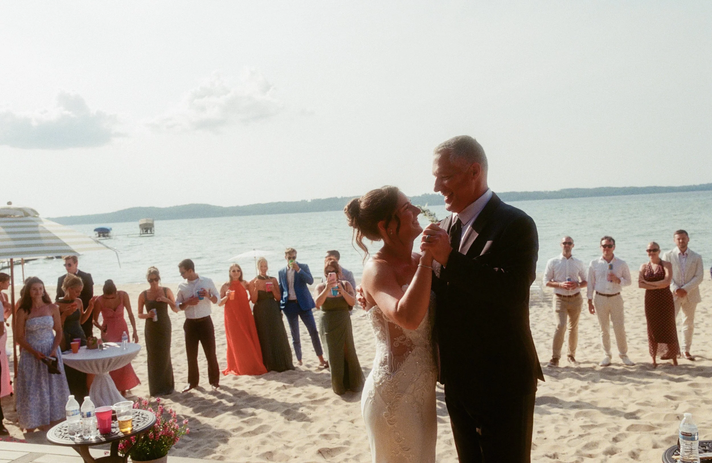 Bride dancing with her father on the beach during the Northern Michigan backyard wedding celebration.