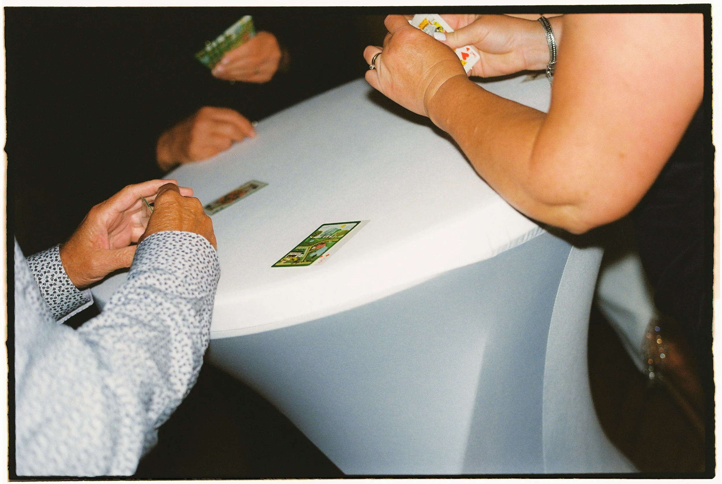 Guests playing cards at a cocktail table during a lively Salvage One wedding reception