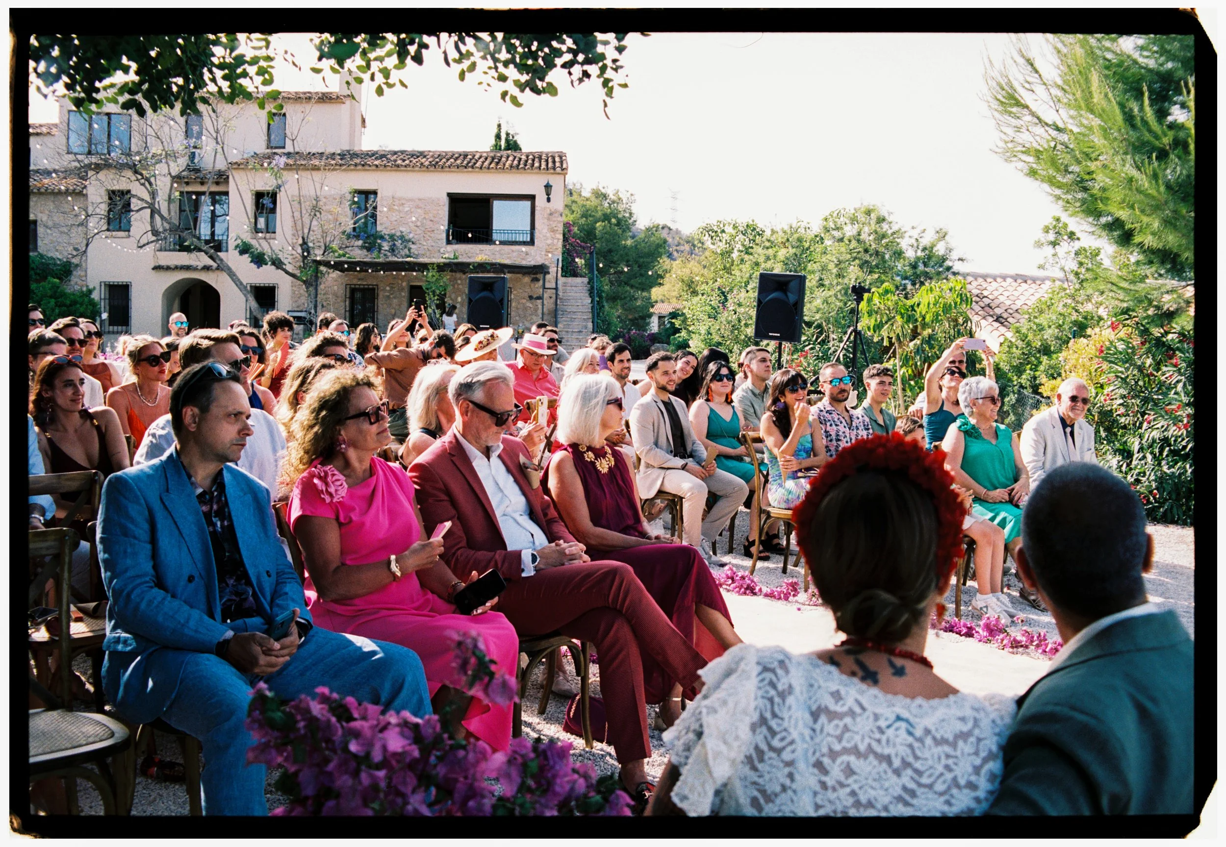 Wedding guests watching the ceremony outdoors at a scenic Spanish villa.