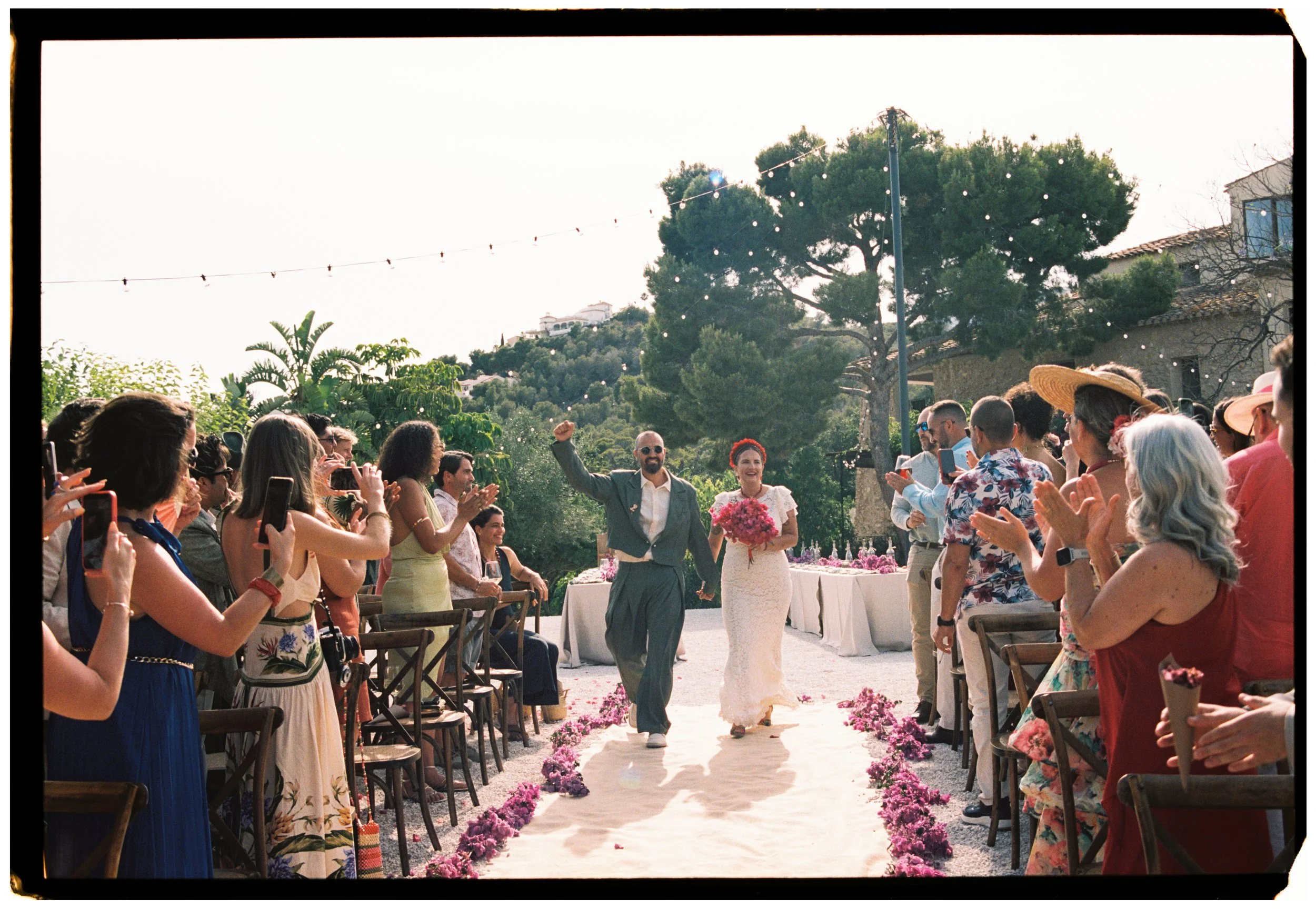 Bride and groom making their grand entrance as guests cheer during a Spain wedding reception.