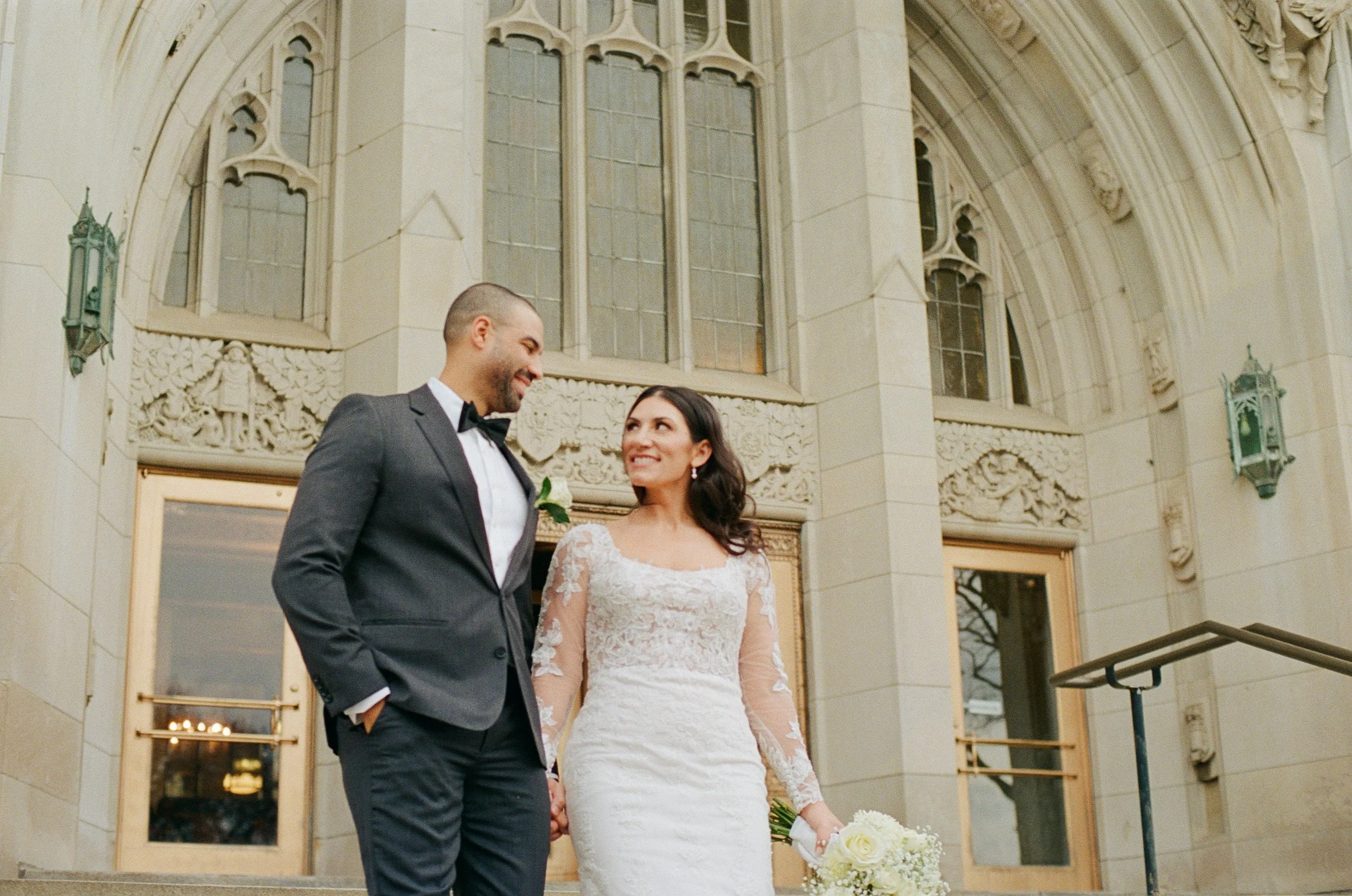 Close-up portrait of the bride and groom smiling at each other outside their downtown Detroit wedding venue.