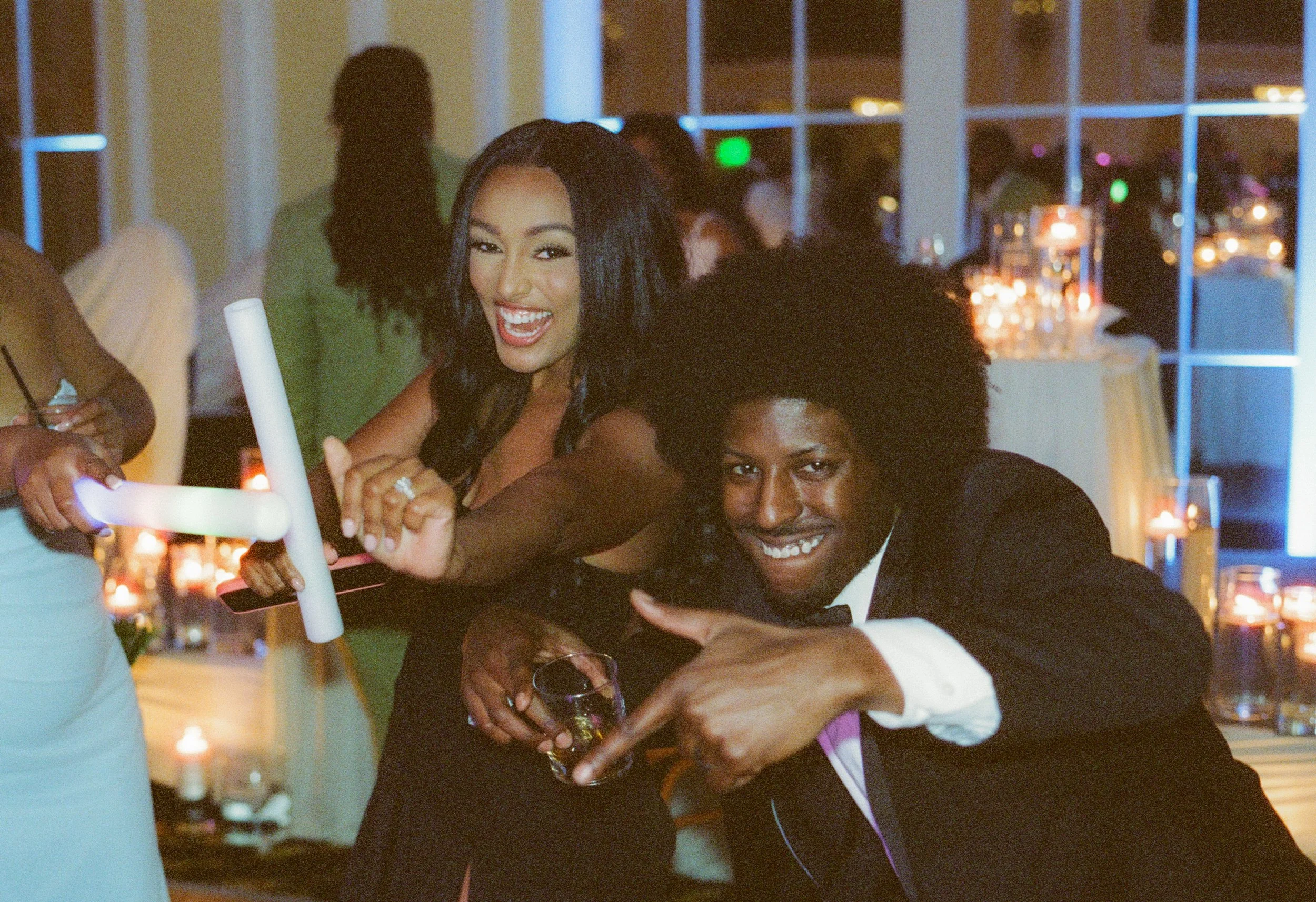 Wedding guests dancing and celebrating with glow sticks during the reception party
