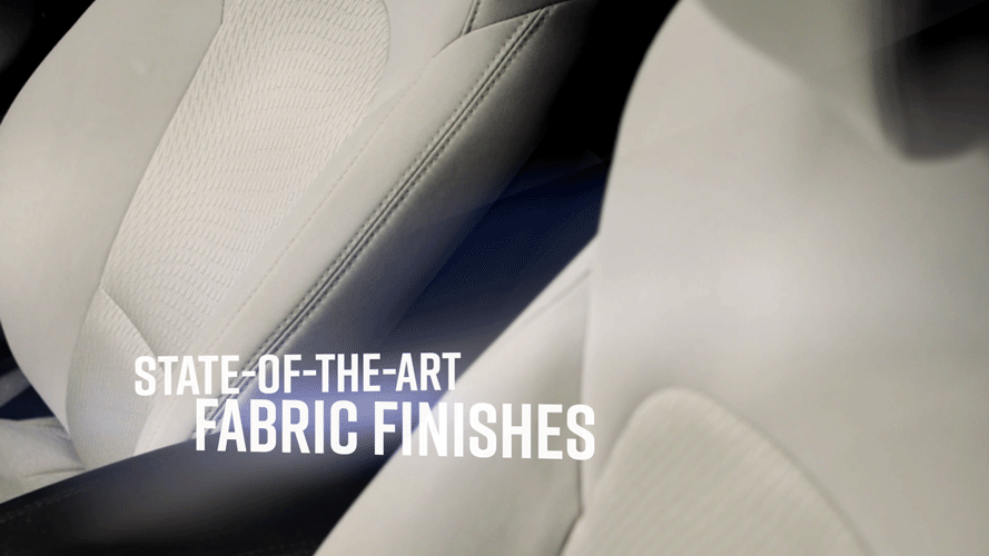 Close-up of beige car seats showing fabric finish, with text "State-of-the-art fabric finishes" overlaid.