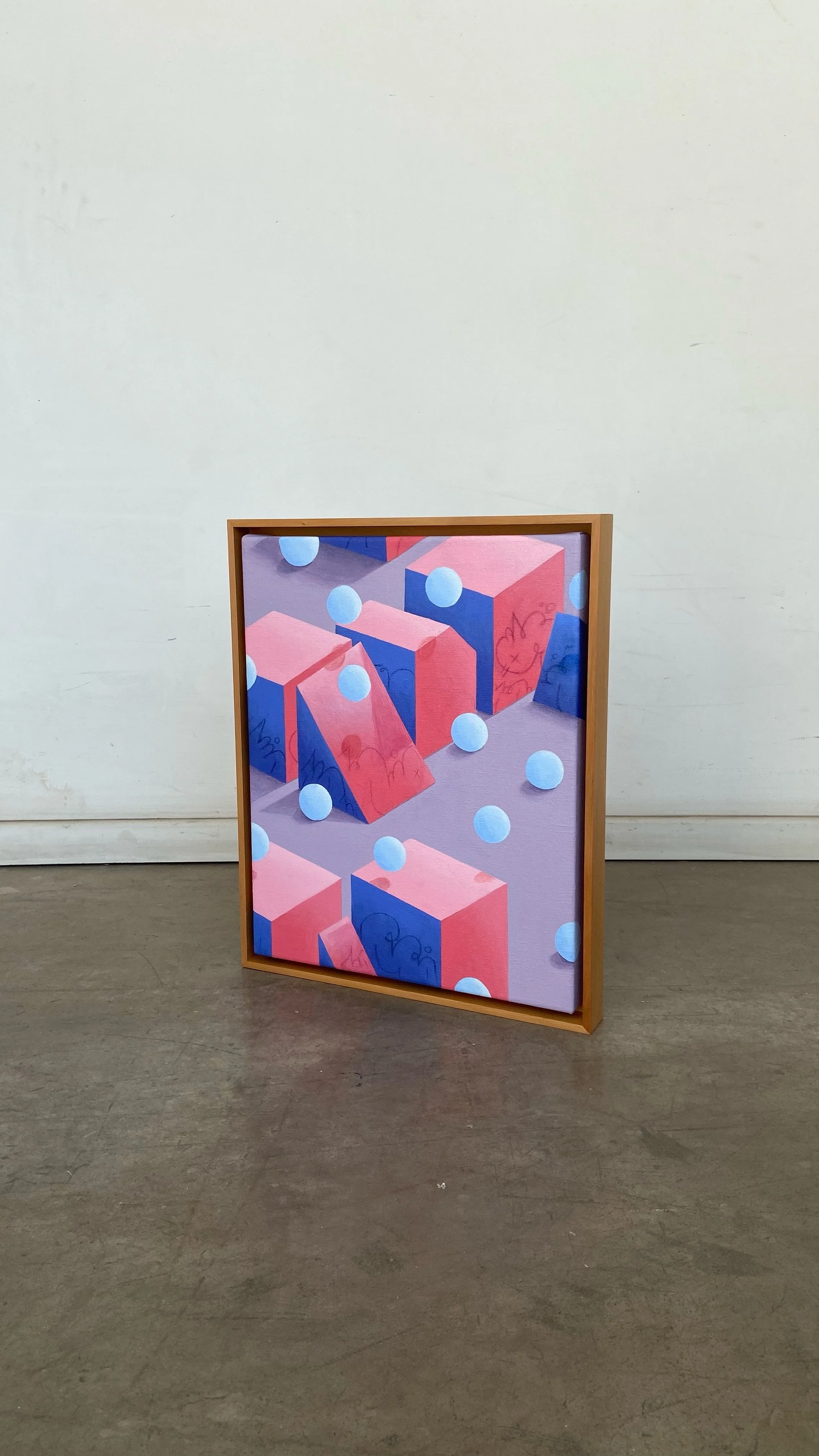 Colorful abstract painting with geometric shapes and falling spheres, framed and standing on the floor in a gallery.