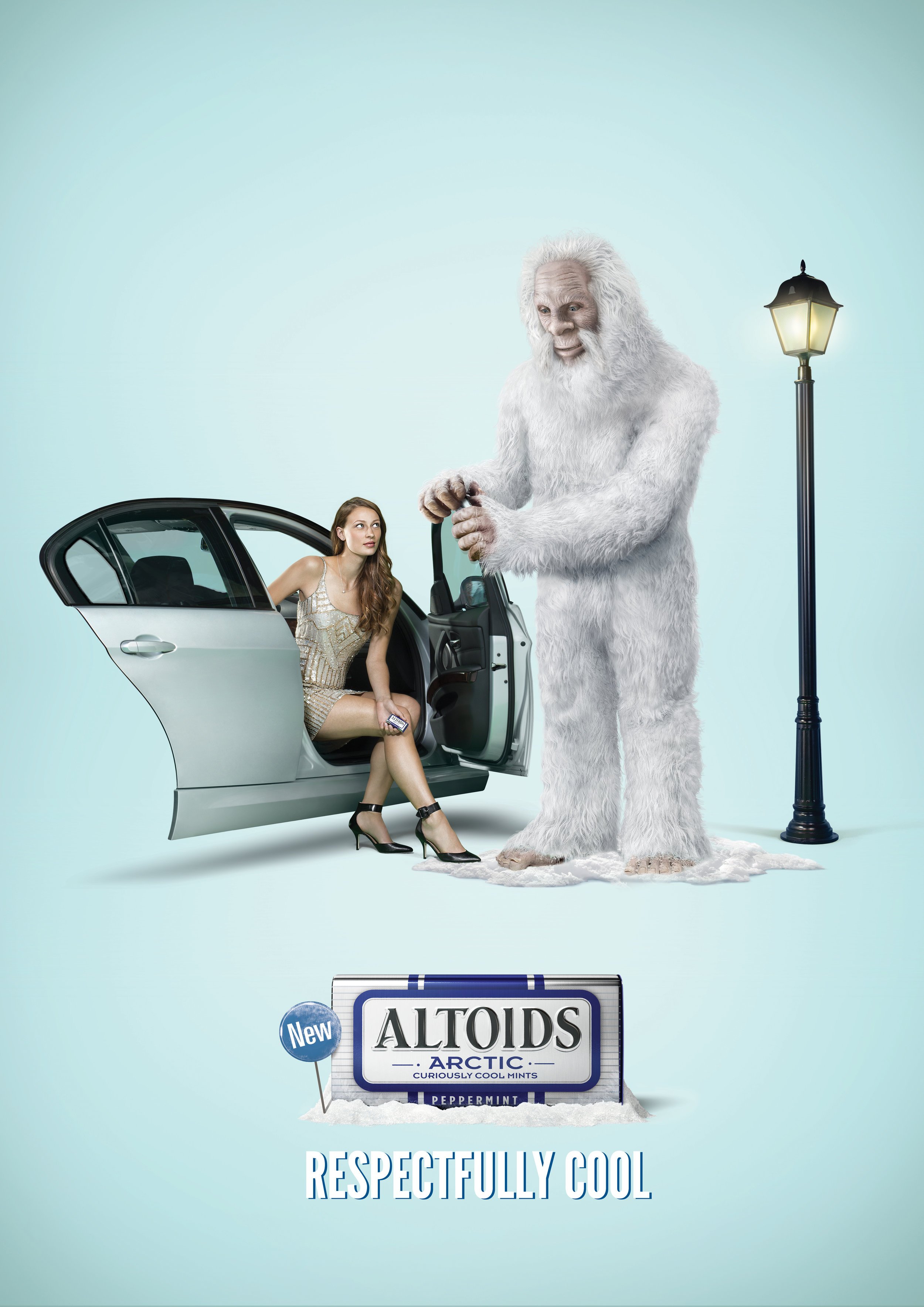 An advertisement featuring a young woman sitting in a car door, holding a phone, next to a large yeti-like creature with white fur, standing by a streetlamp, with snow on the ground, promoting Altoids Arctic mints and the slogan "Respectfully Cool."