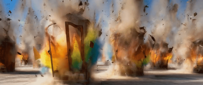 Multiple explosions with fire and smoke in a pyrotechnic display, including a large explosion in the center with a wooden frame.