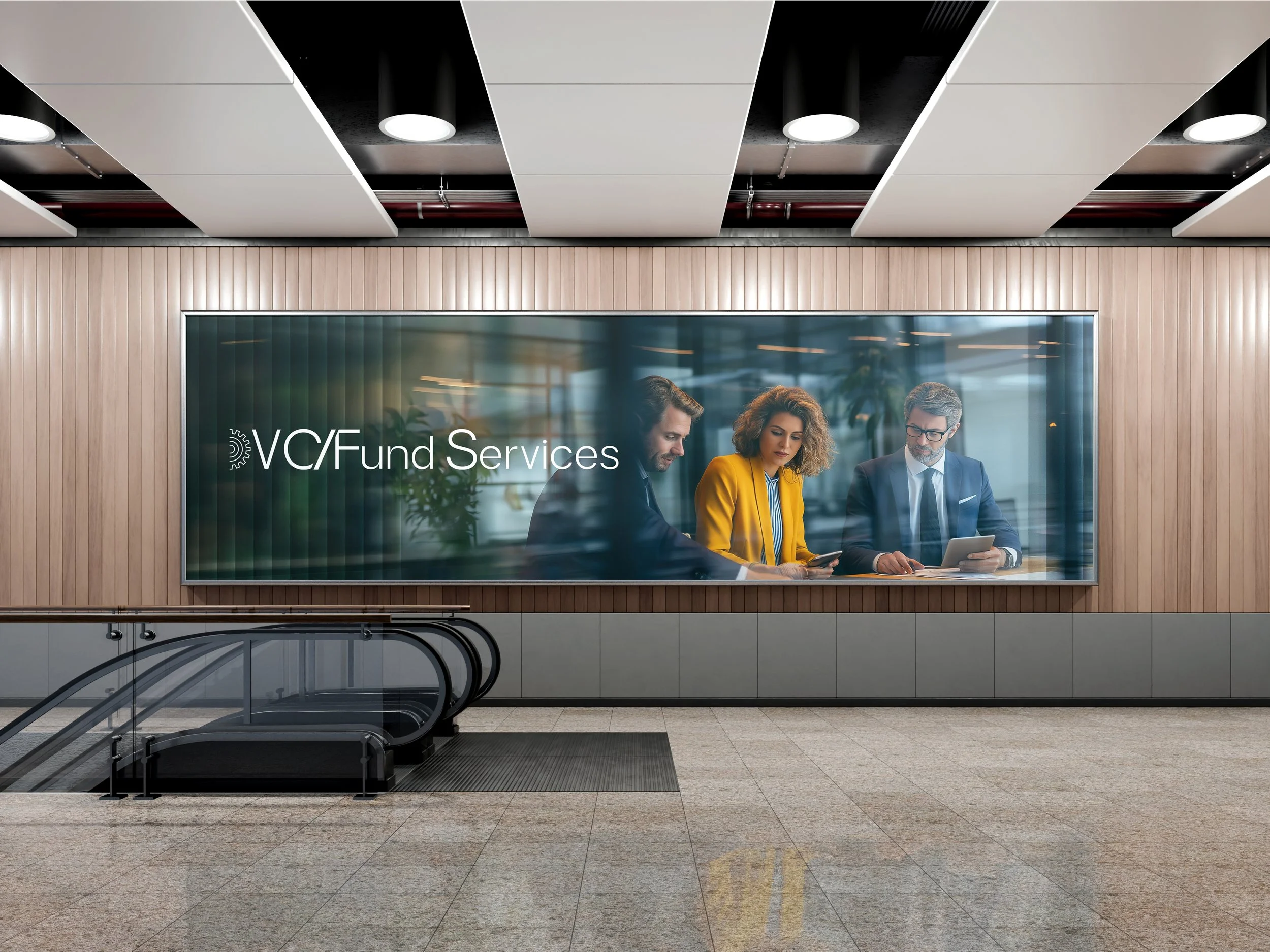 A corporate setting with a large window logo displaying 'VC/Fund Services' and three business professionals, two men and one woman, sitting at a table engaged with digital devices.