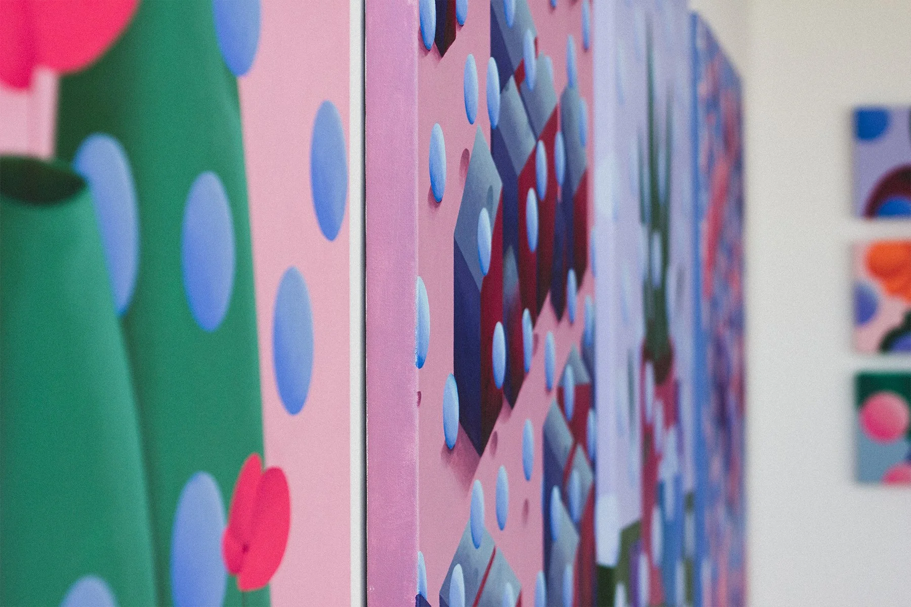 Close-up of colorful abstract pattern on a series of panels, featuring dots and geometric shapes in pink, blue, green, red, and purple.