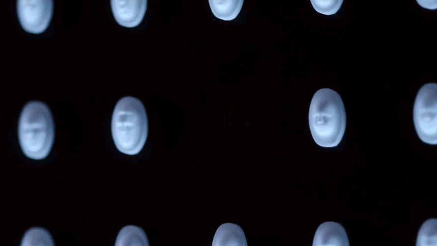 Close-up of a vending machine with rows of illuminated capsule toy slots.