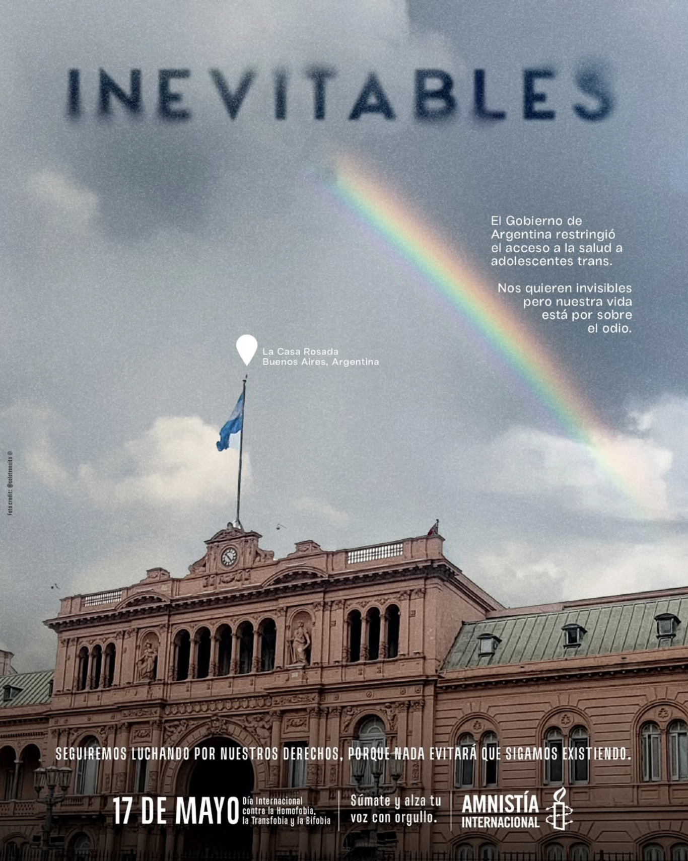 Historic pink building in Buenos Aires with a flag and a clock, dark clouds and rainbow in the sky. Text overlay about LGBTQ+ rights and International Day against Homophobia, Transphobia, and Biphobia on May 17.