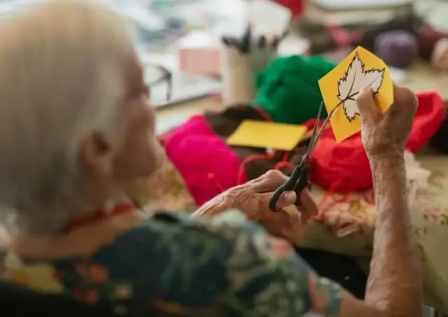 Older adult completing a craft activity used in cognitive communication therapy for Parkinson’s disease to support attention, coordination, and daily functioning.