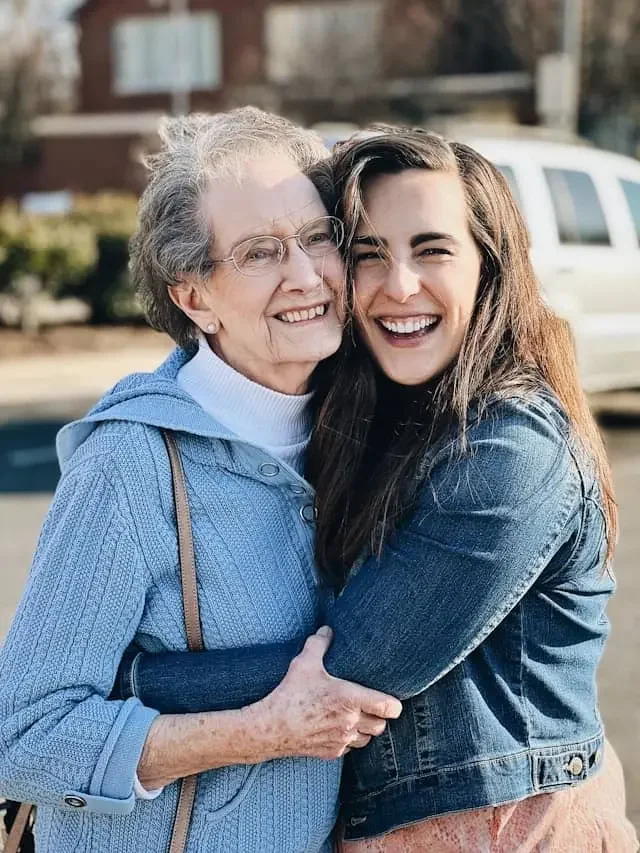 Senior woman hugging her daughter, representing family support and caregiver training in Parkinson’s disease speech and communication therapy.