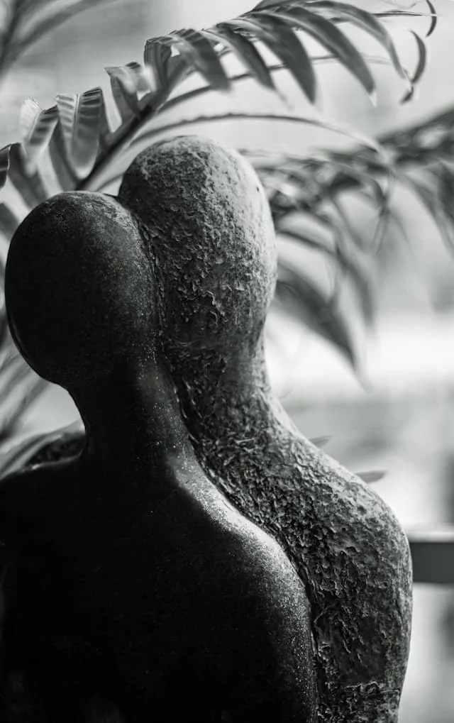 abstract sculpture of two figures leaning together symbolizing caregiver support and emotional connection for people with Parkinson’s