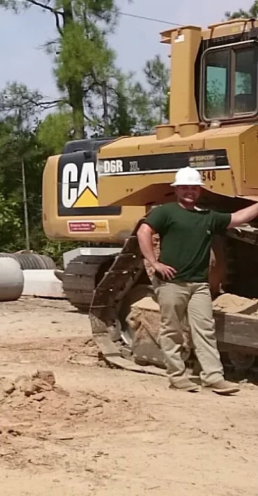 Grading Company Owner Standing Next To Bulldozer