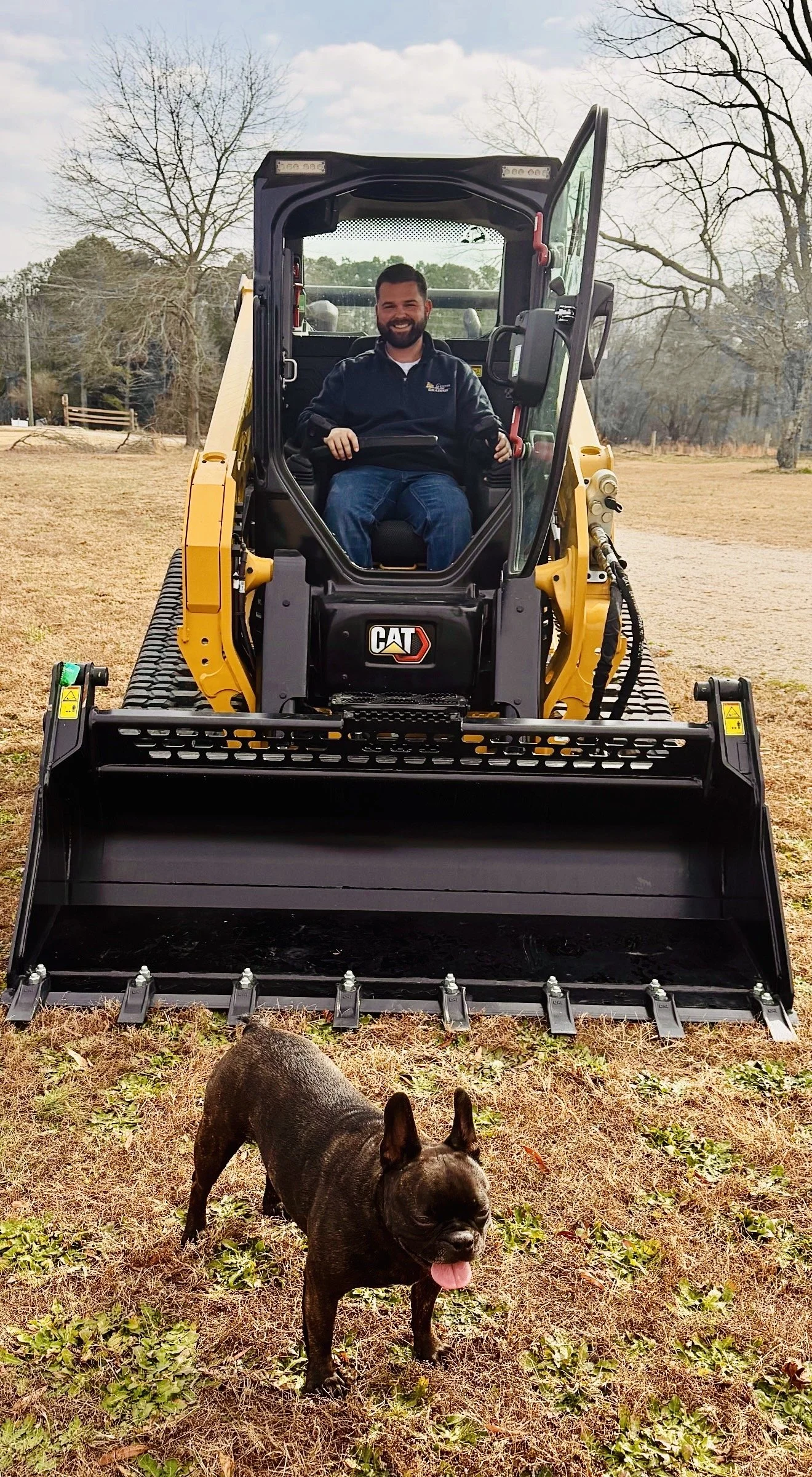 man and dog grading contractor and dog cat skid loaded 255CTL French Bulldog Caterpillar Excavation Contractor Raleigh Wendell Garner Wilson