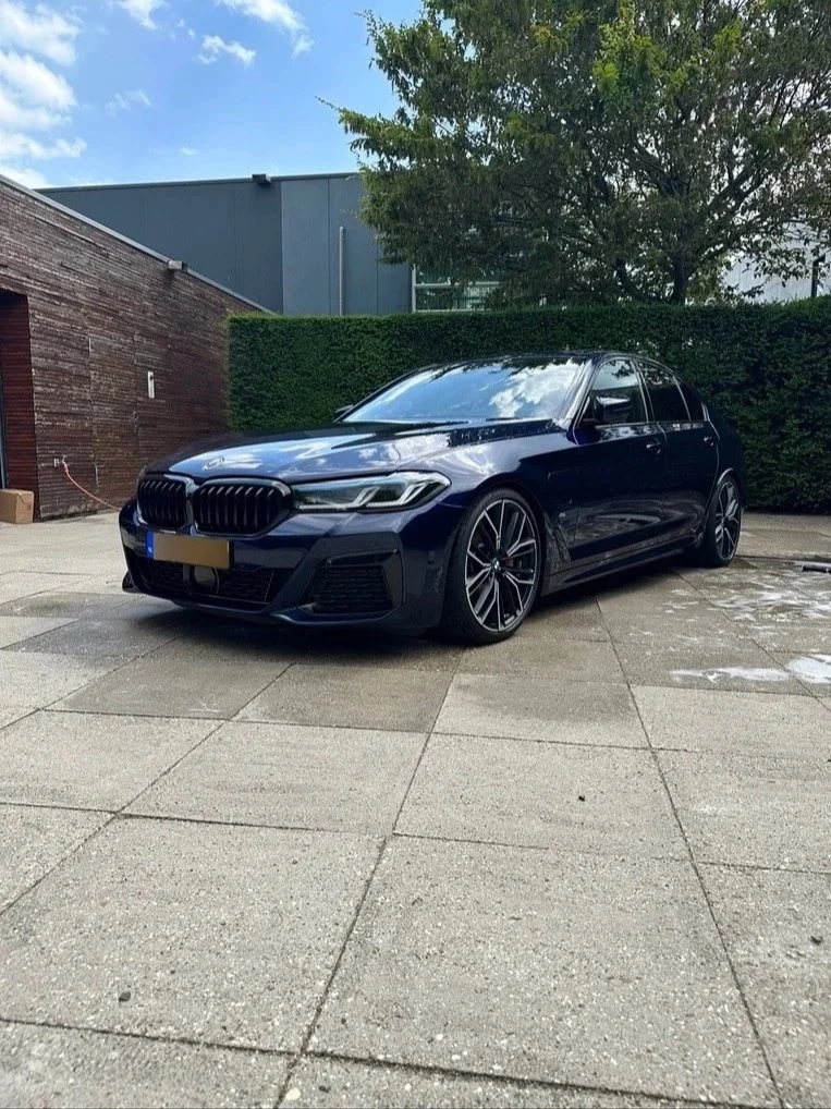 Blauwe BMW sedan die volledig schoon en glanzend is na professionele wasbeurt in Oisterwijk.