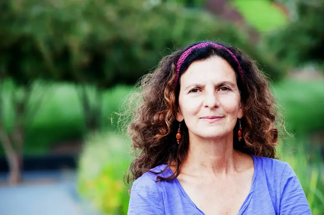 Author, dancer, and healer Cheryl Pallant sitting outside.