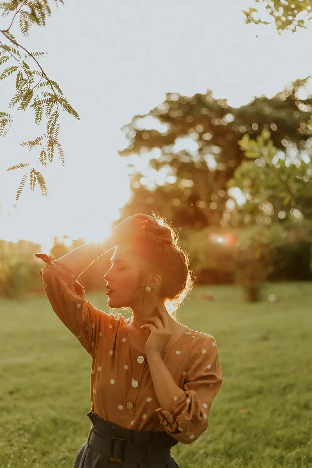 A woman standing outdoors in a park at sunset after Reiki and Healing Touch session with Cheryl Pallant.