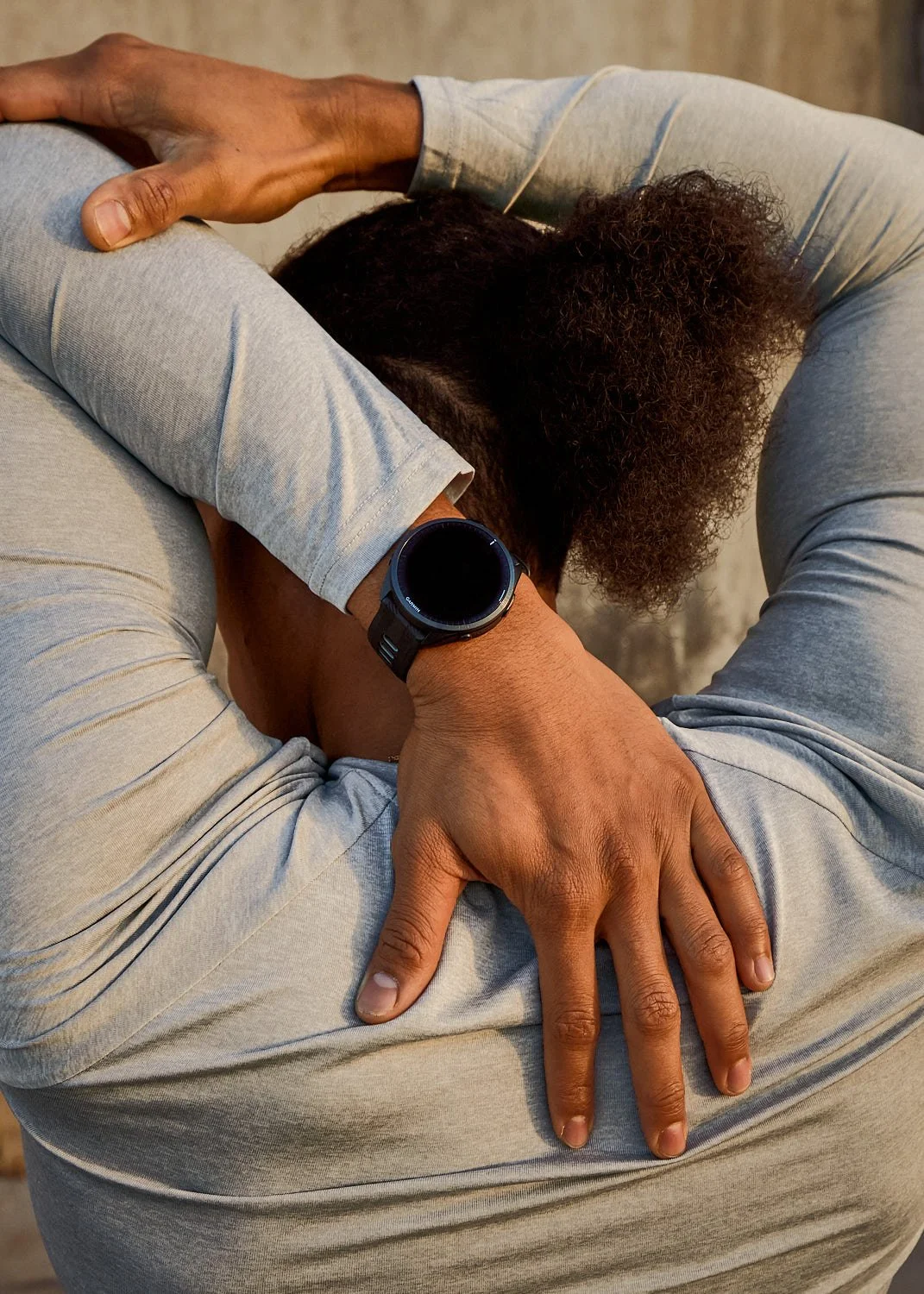 Male runner stretching with garmin watch on wrist, photographed by Matthew Keough