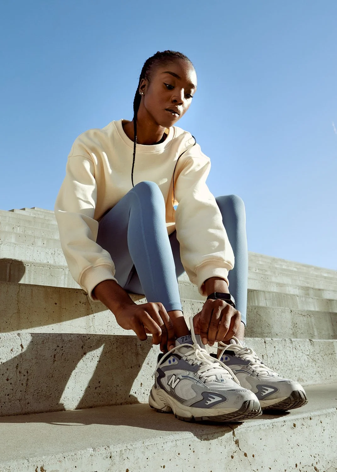 Athlete sitting and adjusting New Balance shoes on stairs in Phoenix