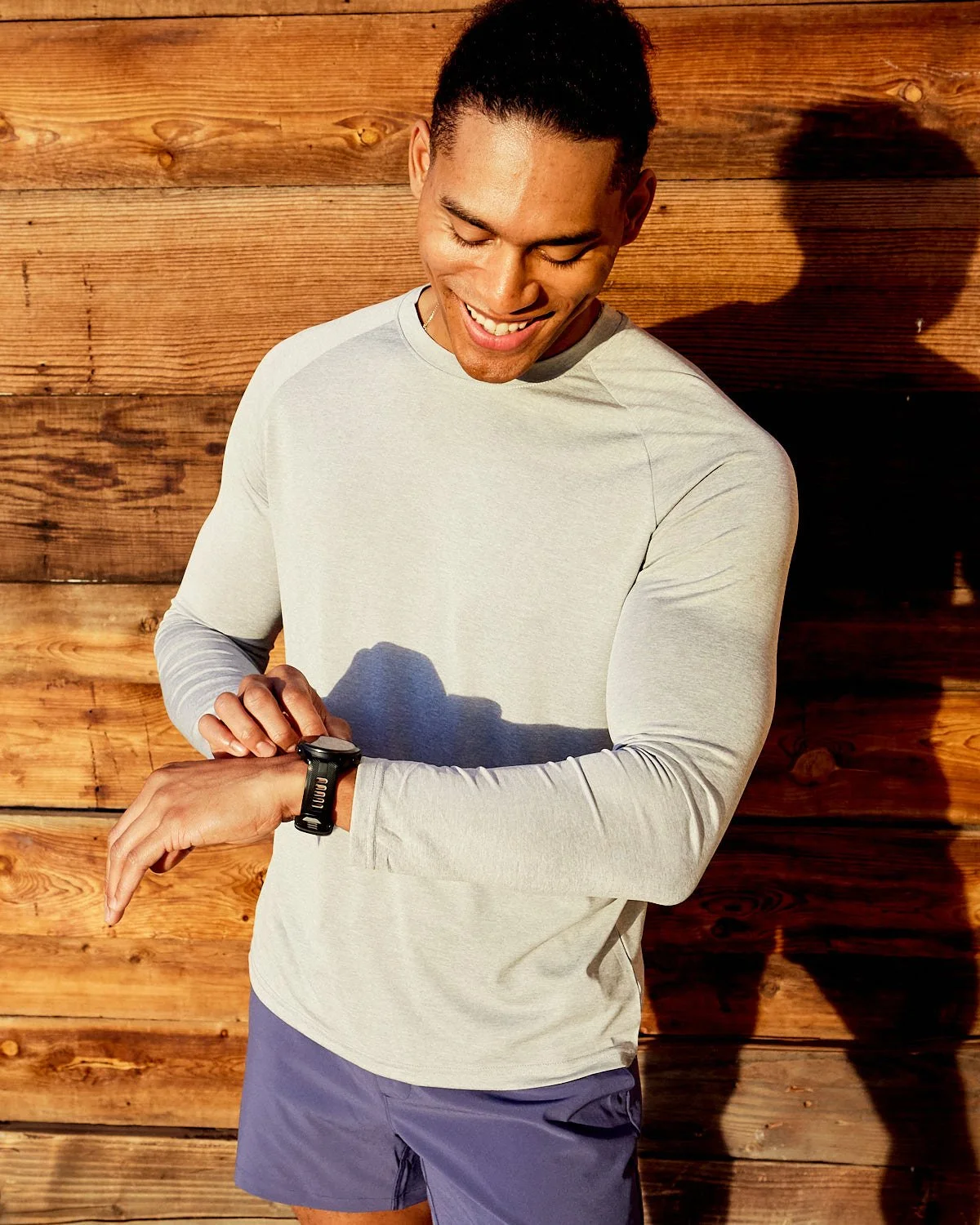 Runner checking Garmin sports watch in early morning sunlight in Arizona