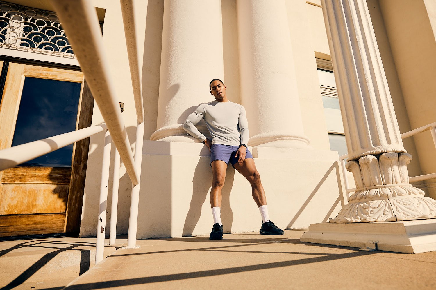 Runner resting at mid century building in the sunlight in Phoenix, Arizona